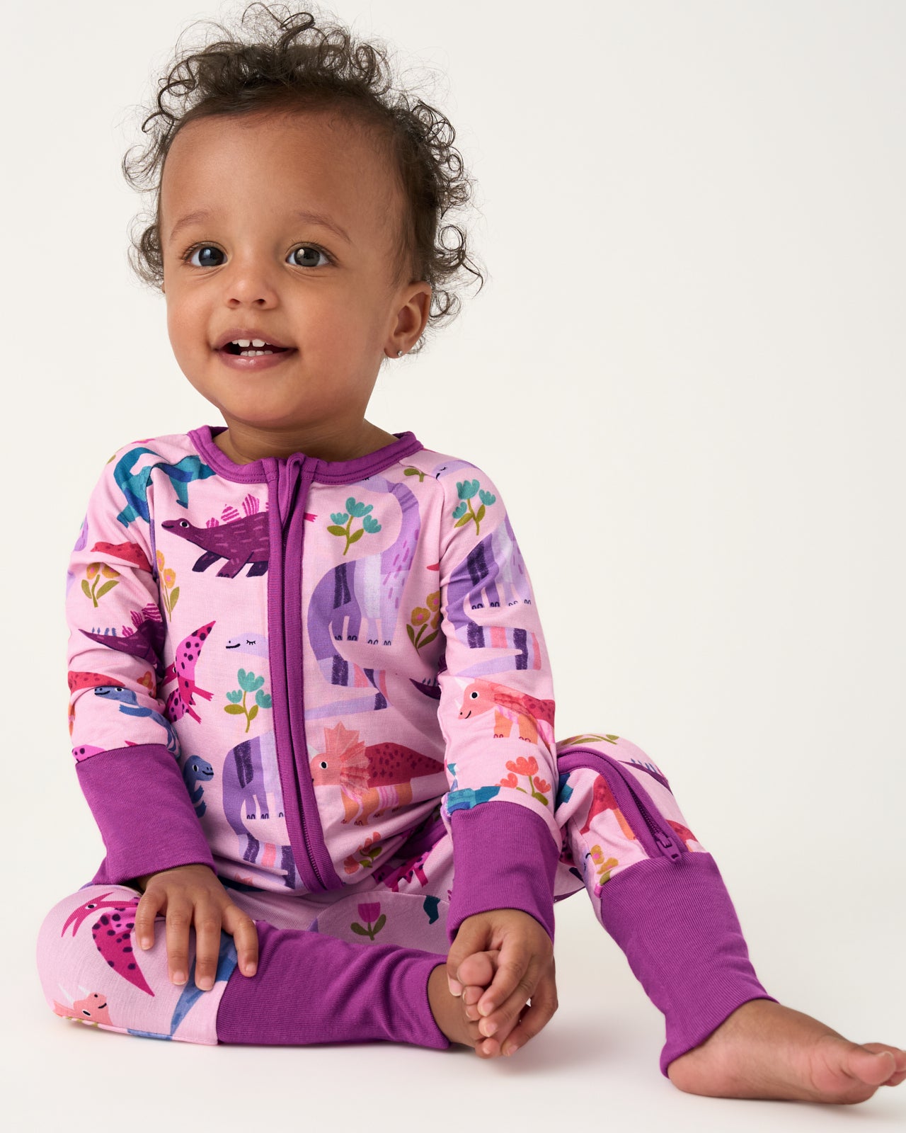 Sitting baby wearing the Pink Roar & Explore Zippy