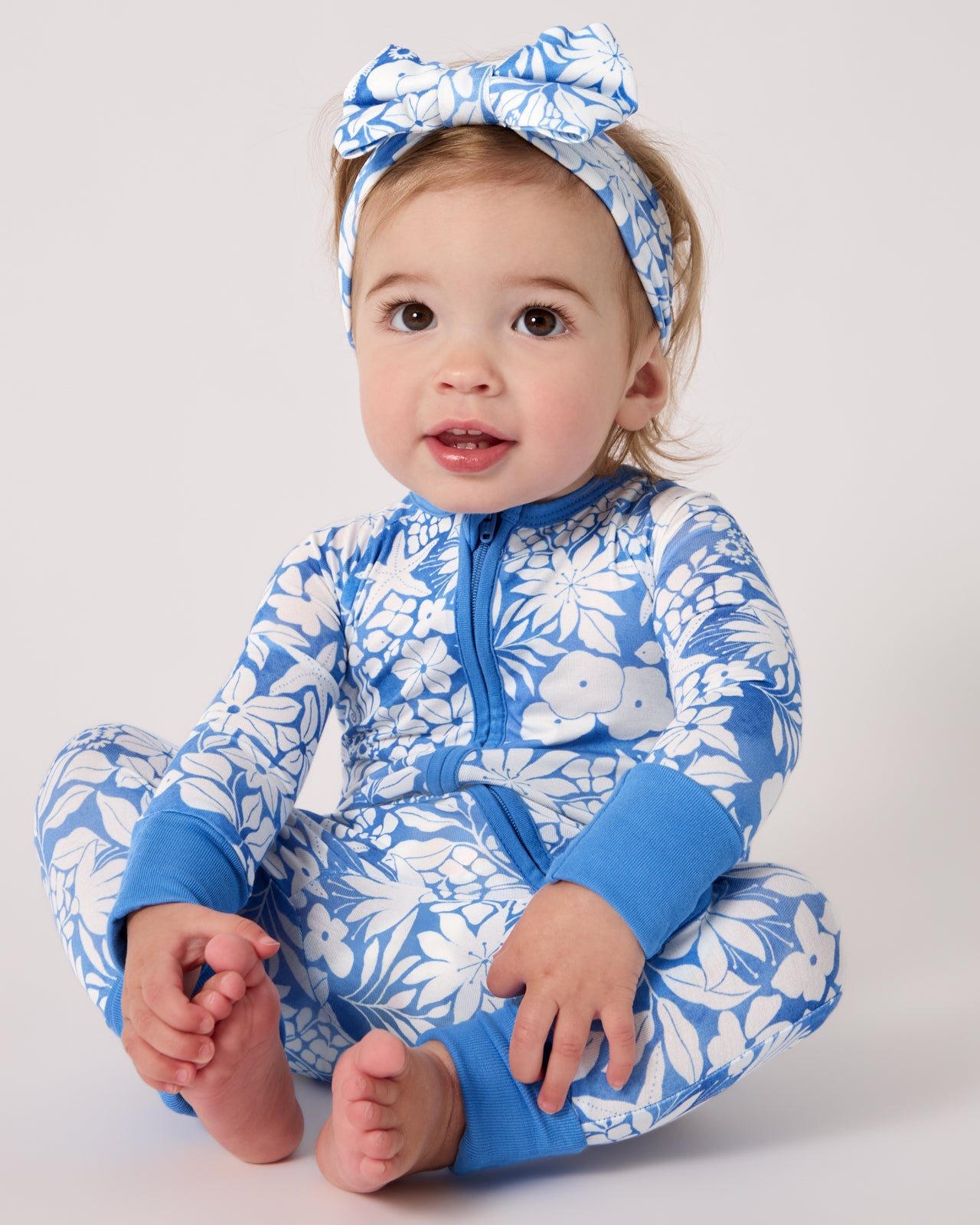 Sitting baby wearing the Azure Garden Zippy and Luxe Bow Headband