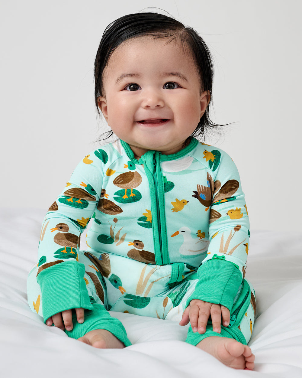 Sitting newborn wearing the Puddle Jumpers zippy