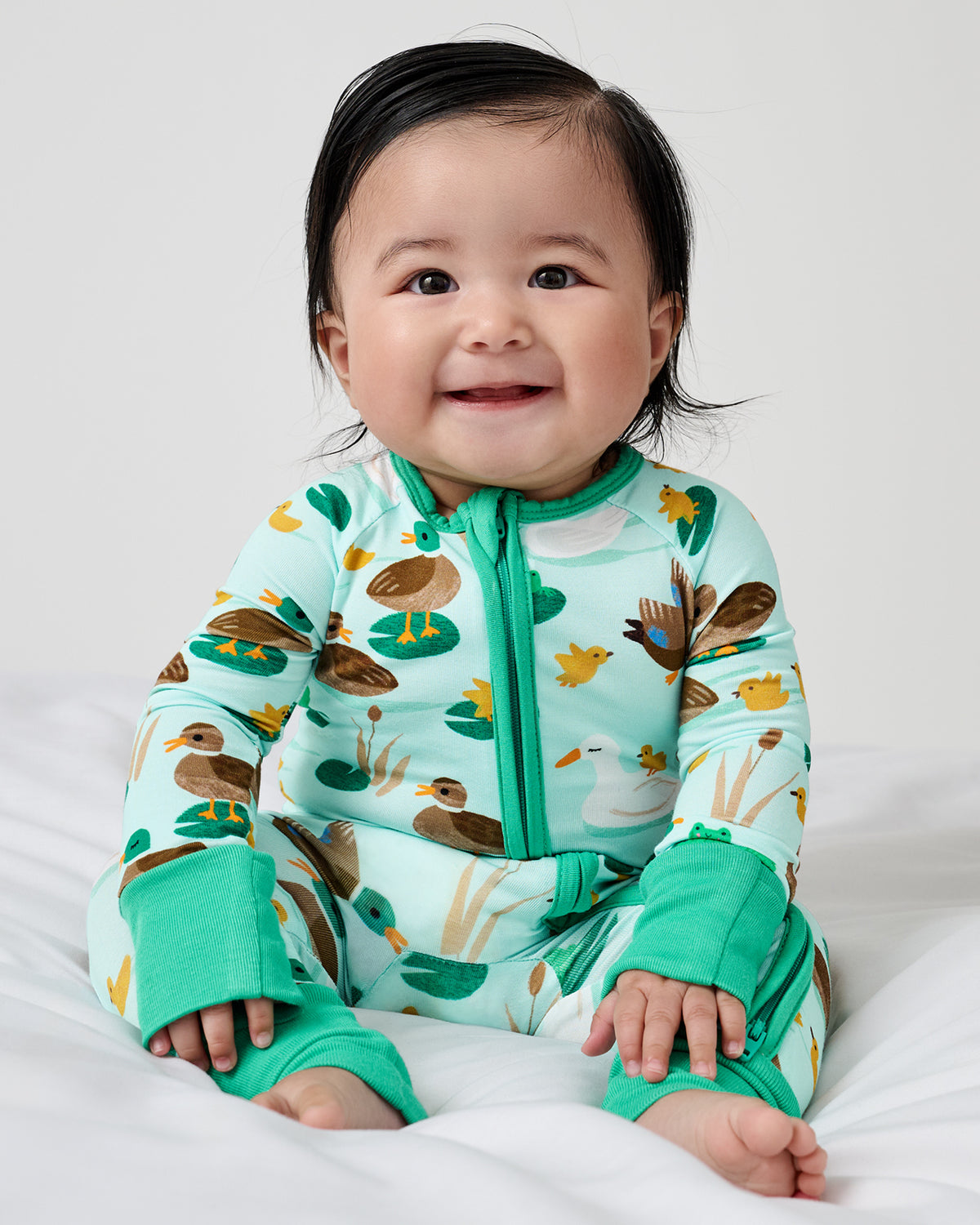 Sitting newborn wearing the Puddle Jumpers zippy