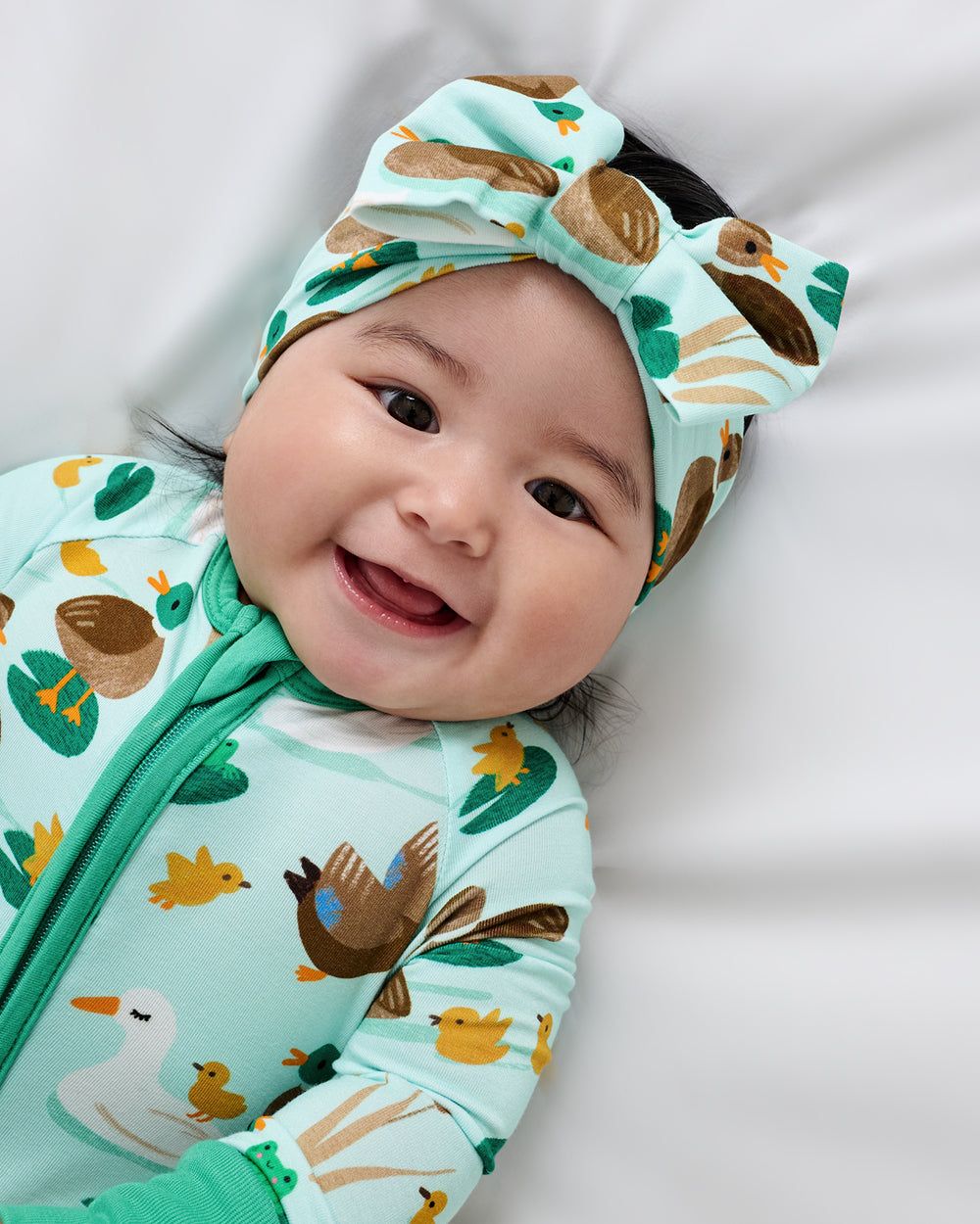 Close up of baby wearing the Puddle Jumpers Luxe Bow Headband