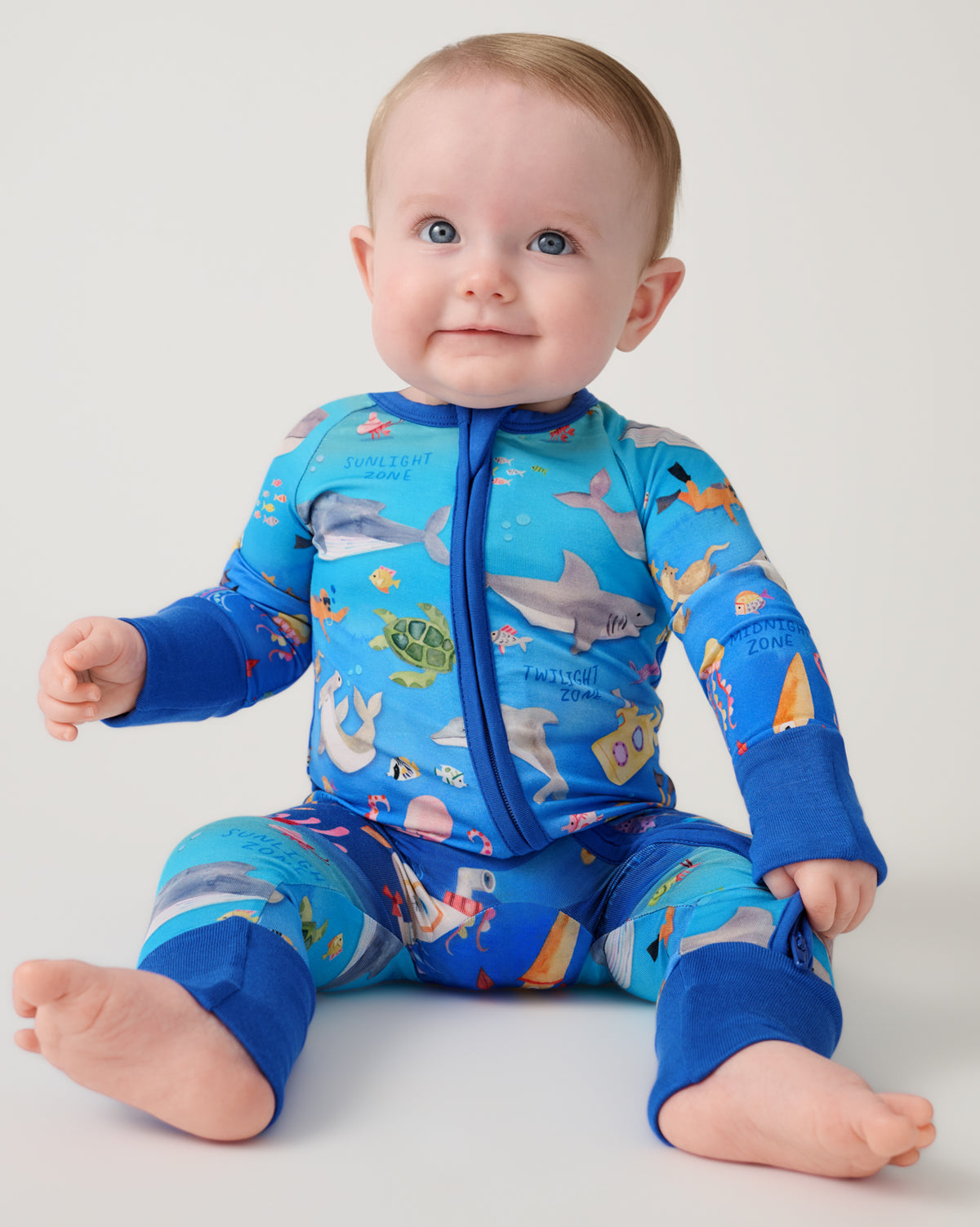Sitting newborn wearing the Underwater Discovery Zippy