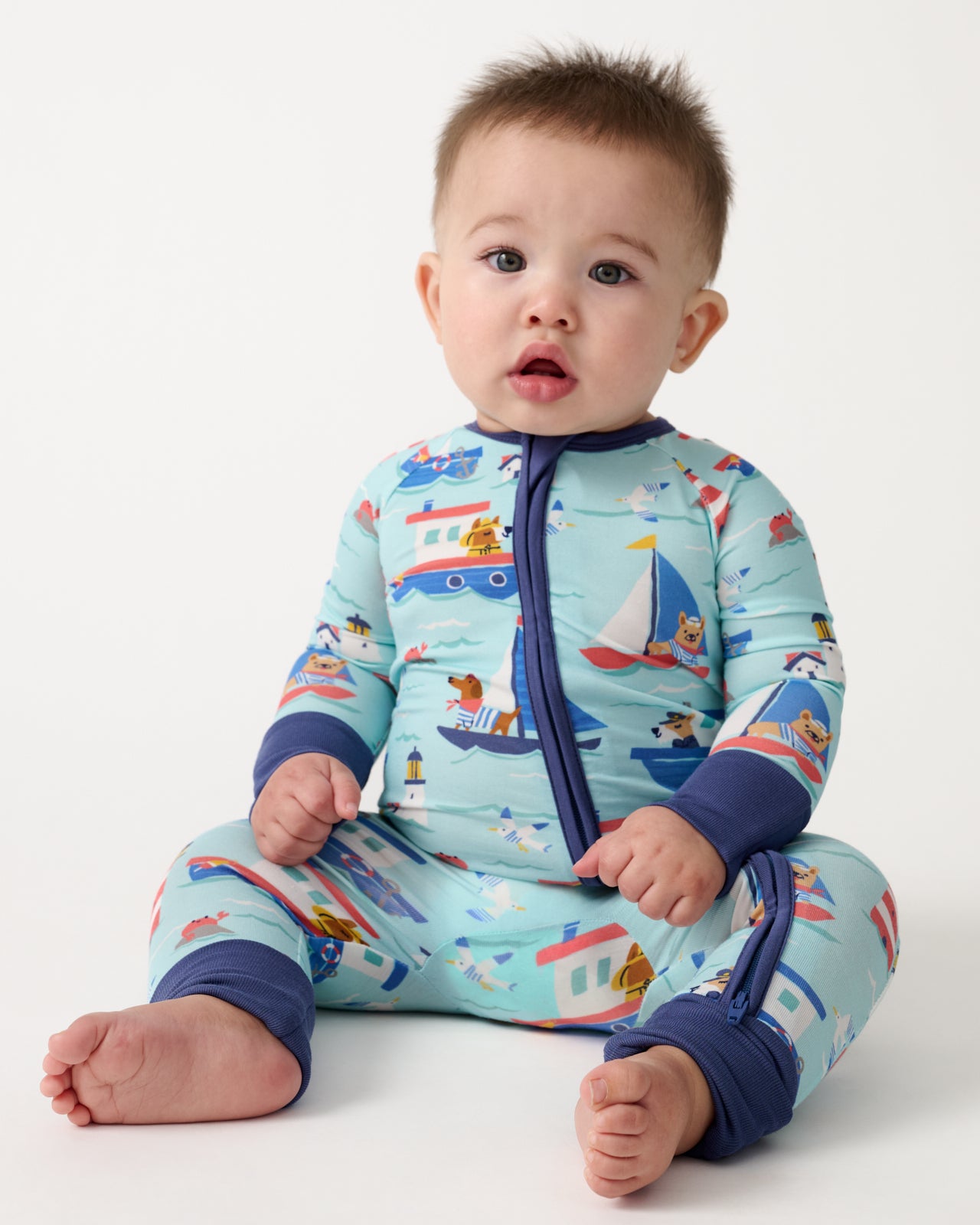 Sitting baby wearing the Nautical Paws Zippy