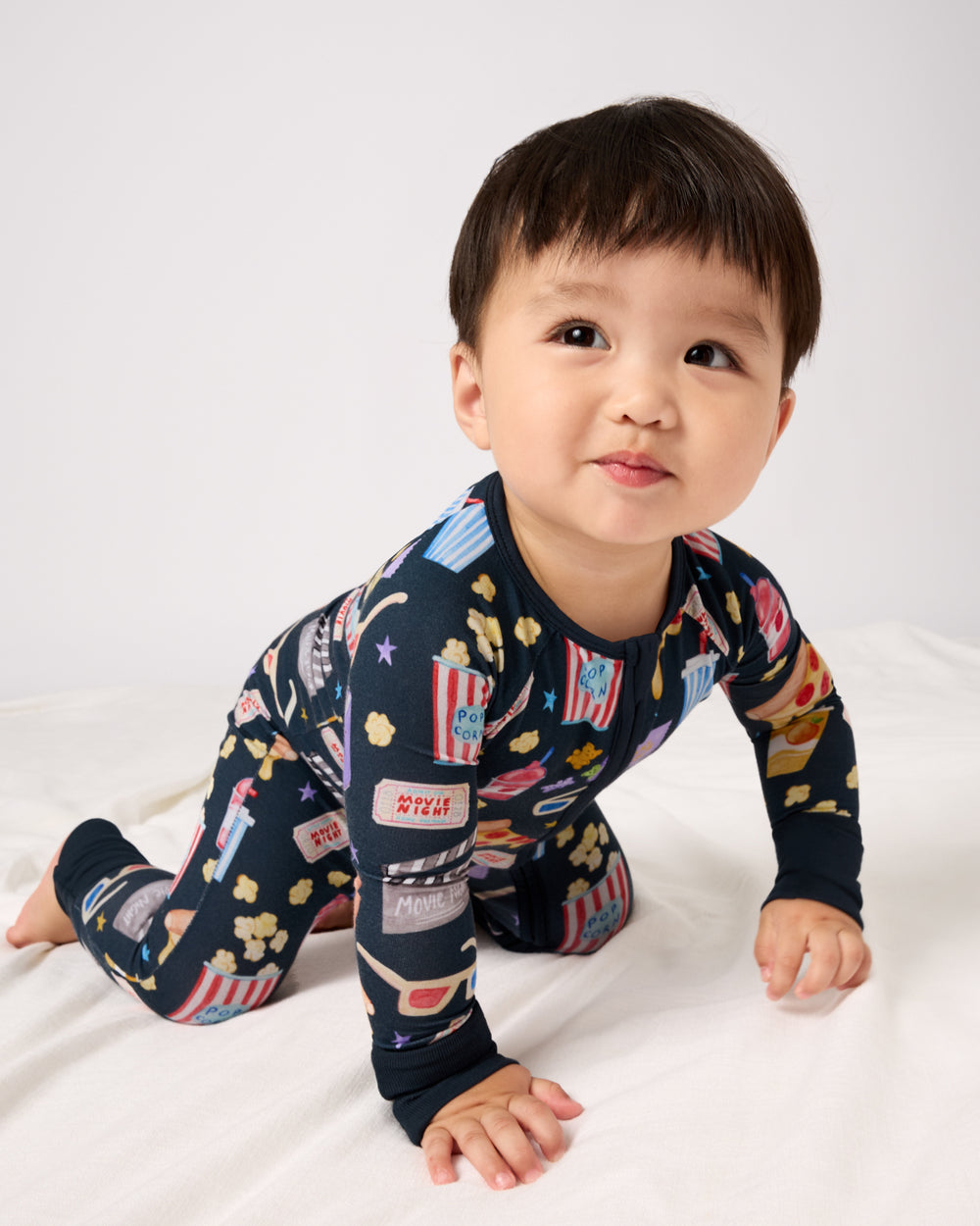 Crawling baby wearing the Movie Marathon Zippy