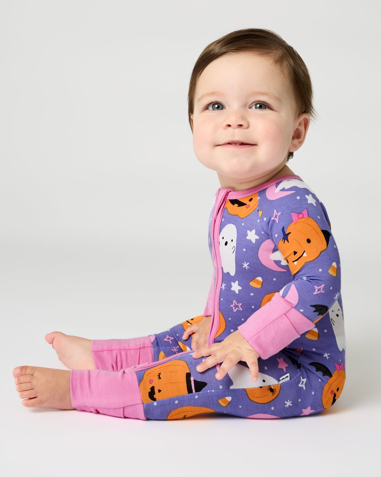 Sitting baby wearing the Moonlit Magic Purple Zippy