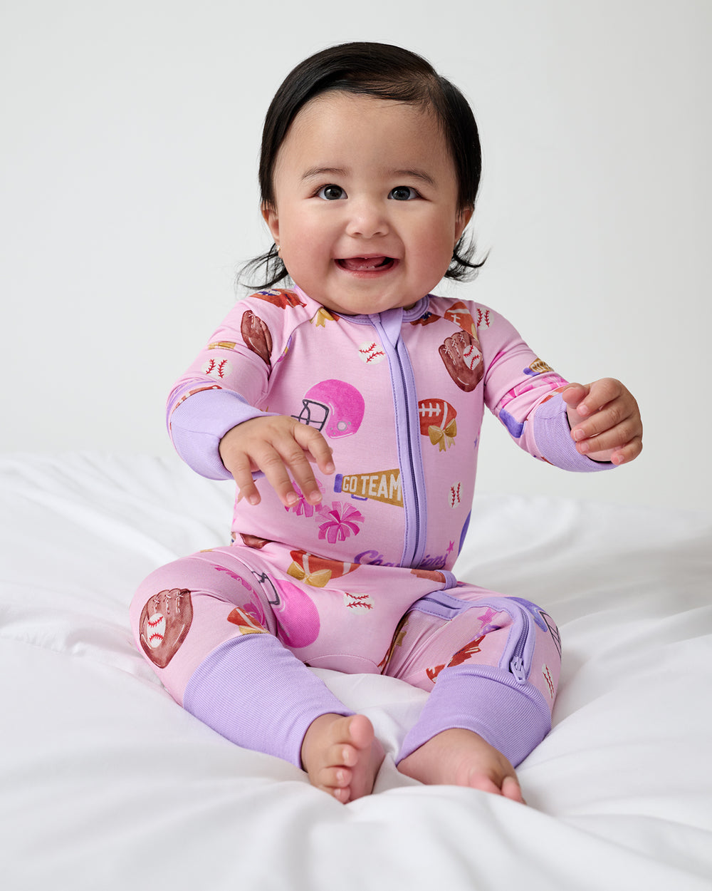 Sitting child wearing the Team Spirit Pink Zippy