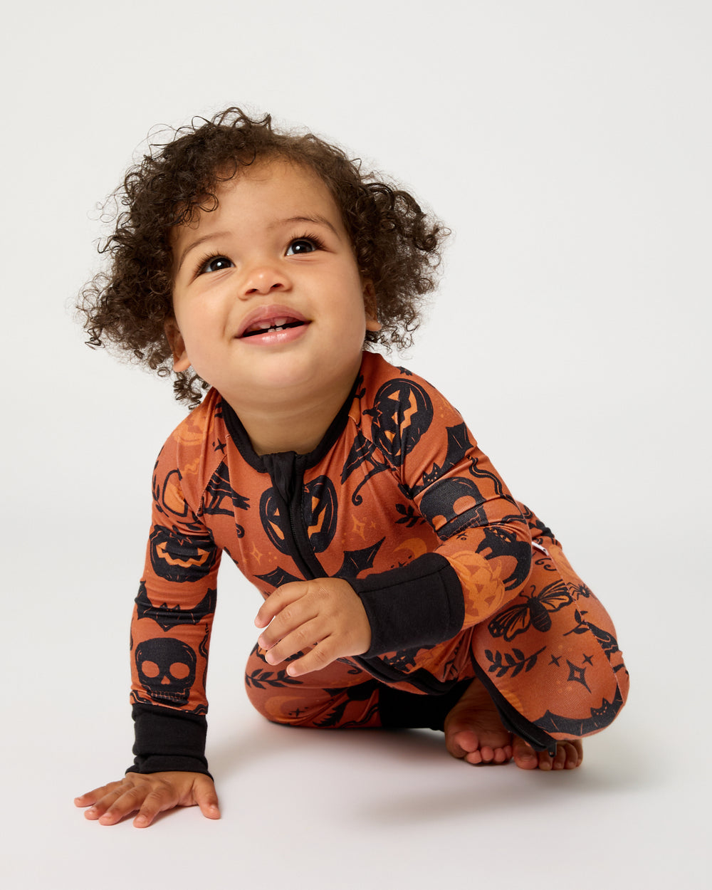 Crawling baby wearing the Midnight Mischief Zippy