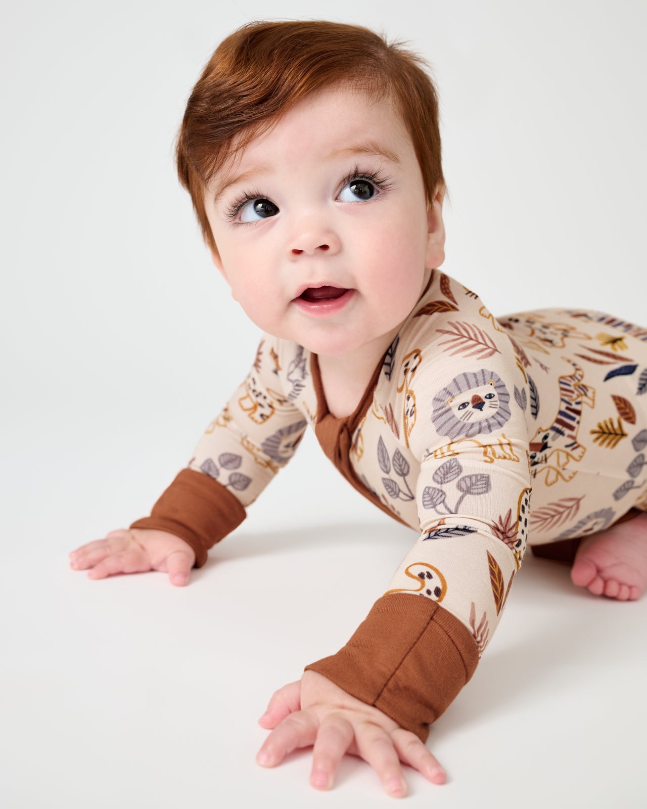 Crawling baby wearing the Savanna Friends Zippy