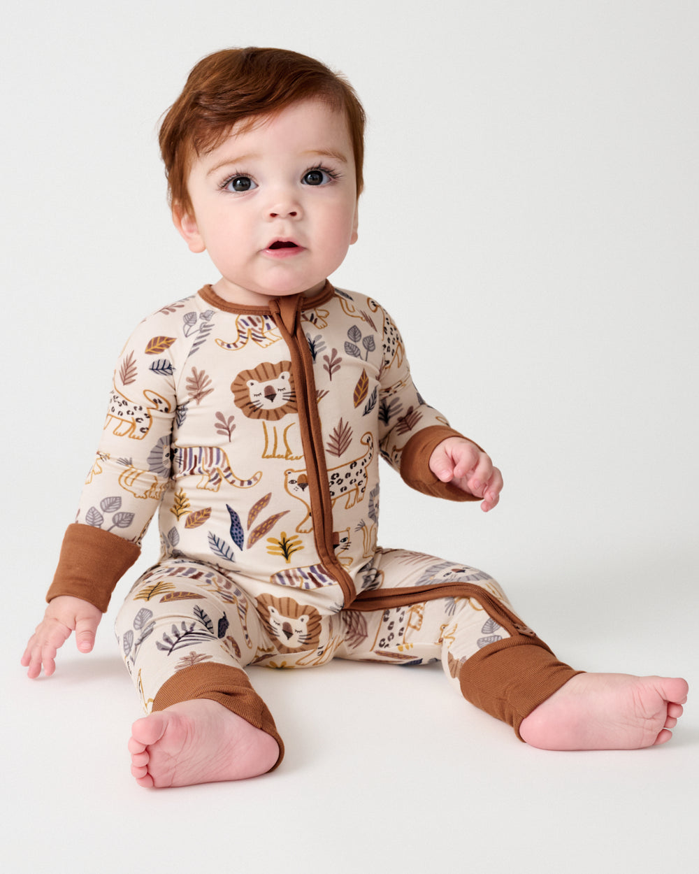 Sitting baby wearing the Savanna Friends Zippy