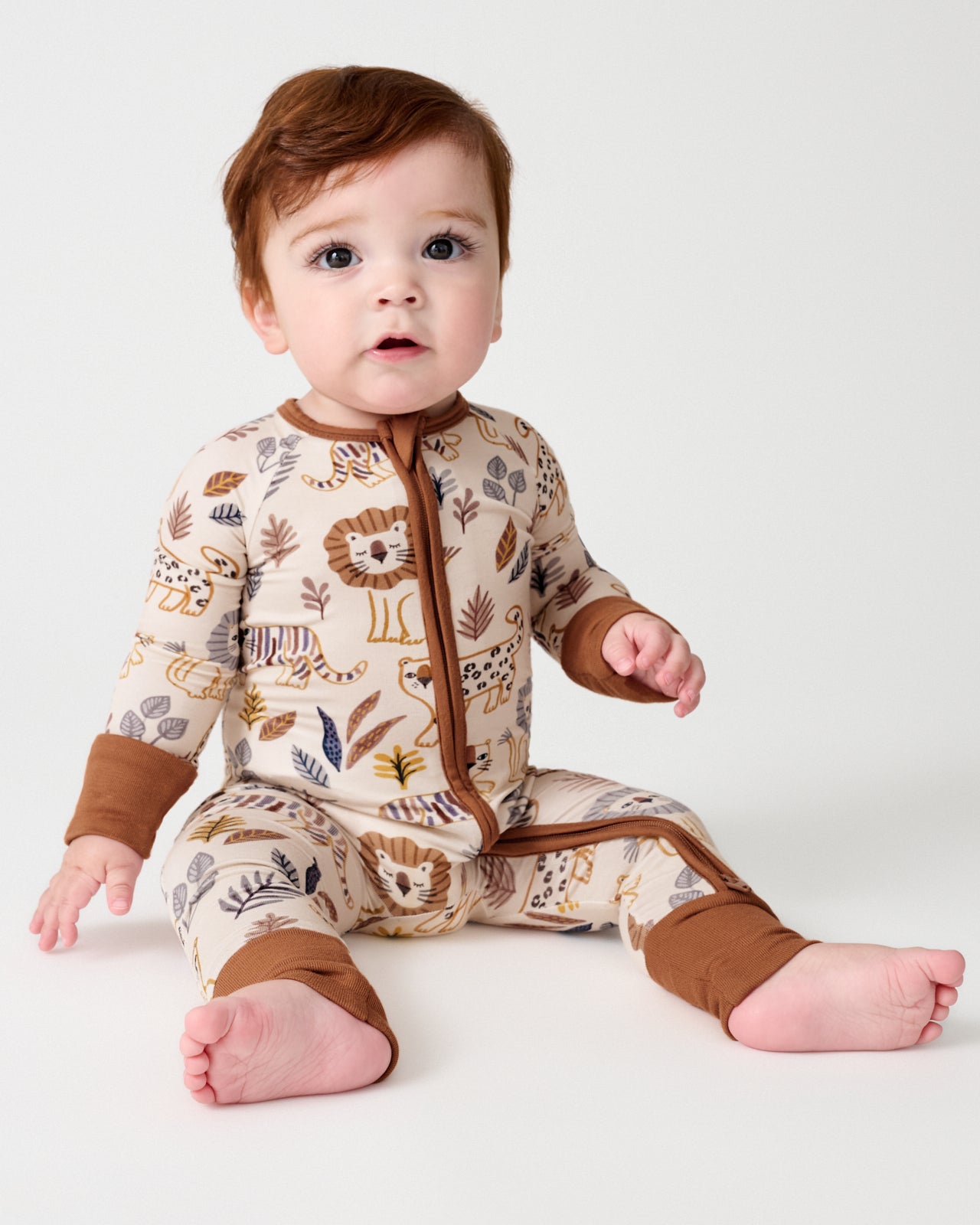 Sitting baby wearing the Savanna Friends Zippy