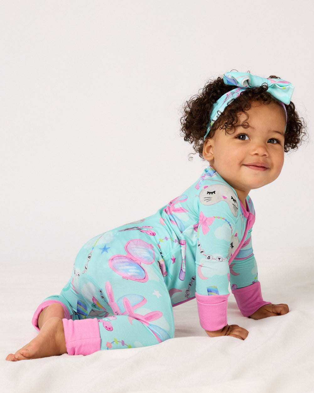 Crawling baby wearing the Slumber Club Zippy