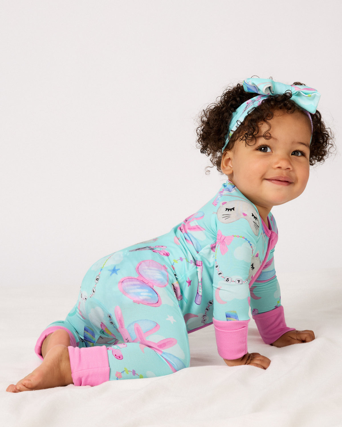 Crawling baby wearing the Slumber Club Zippy