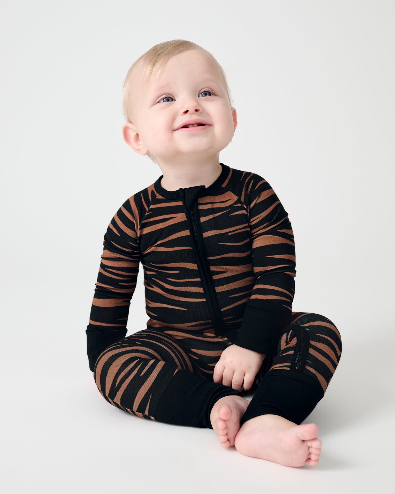 Sitting baby wearing the Wild Stripes Zippy