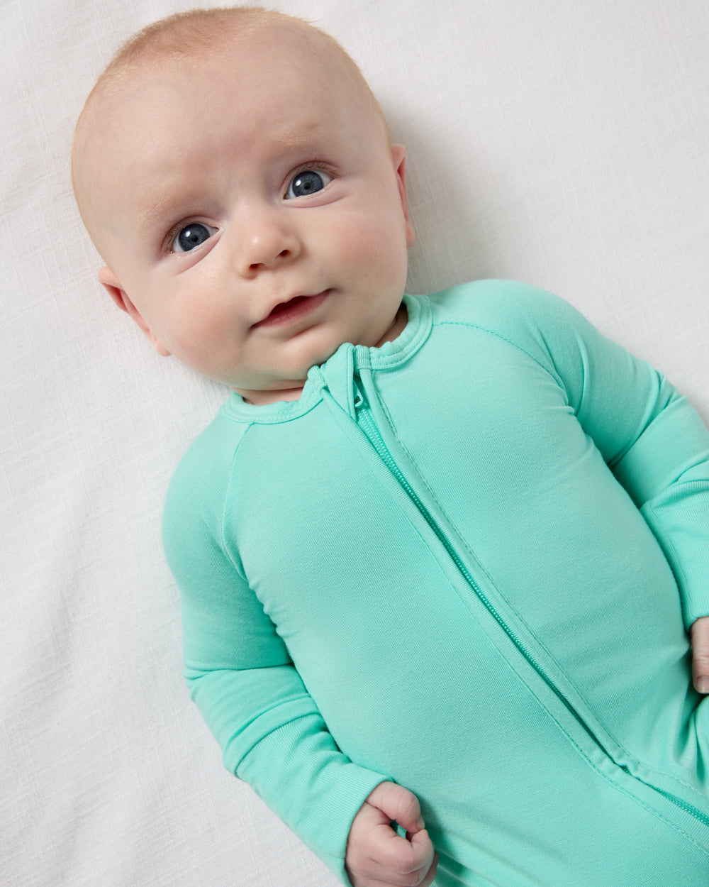 Close up aerial view of baby wearing the Ocean Mist Zippy