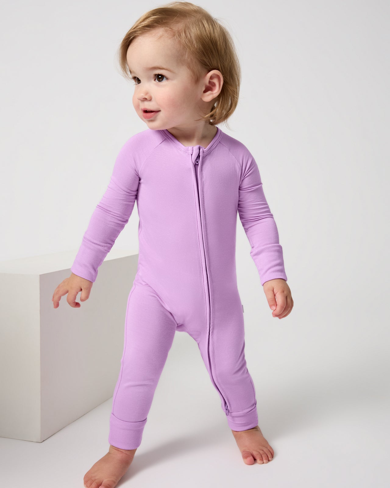 Walking baby wearing the Soft Wisteria Zippy