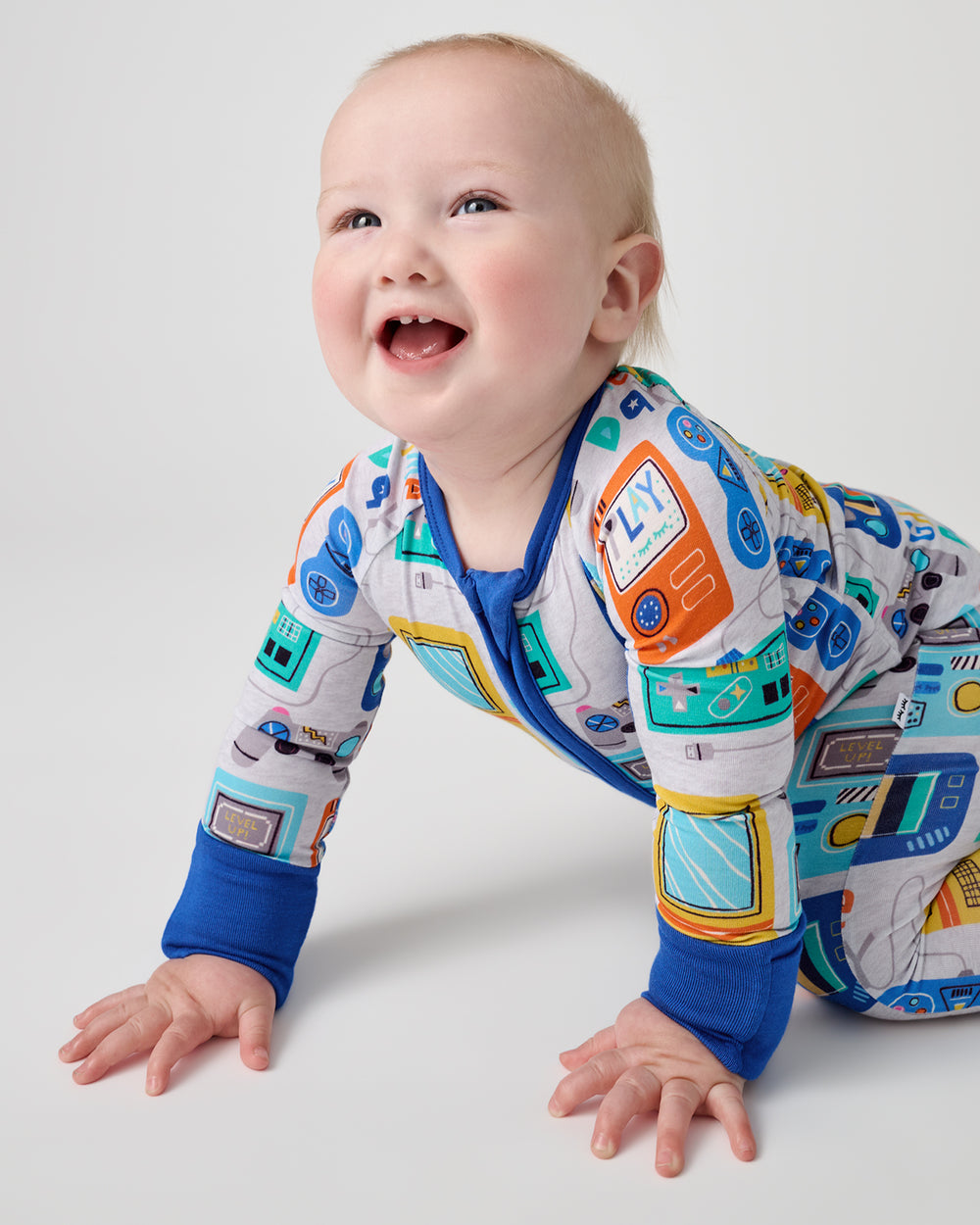 Crawling baby wearing the Game On Zippy