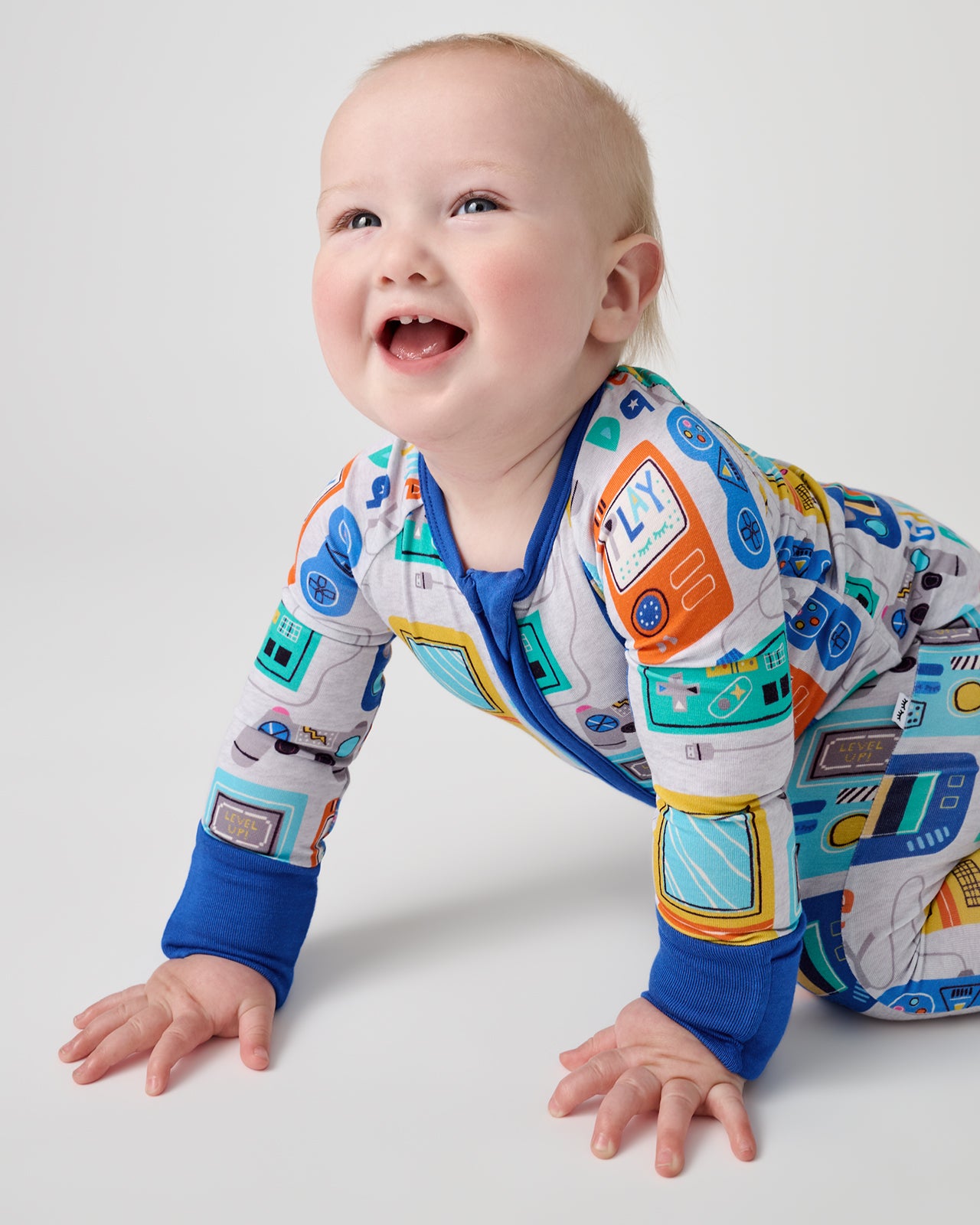 Crawling baby wearing the Game On Zippy