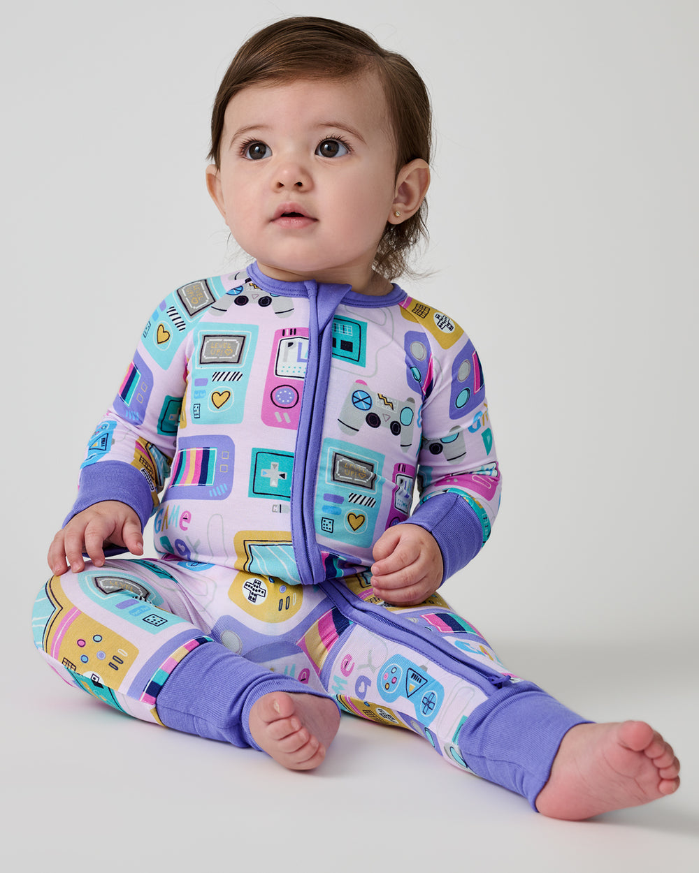 Sitting baby wearing the Purple Game On Zippy