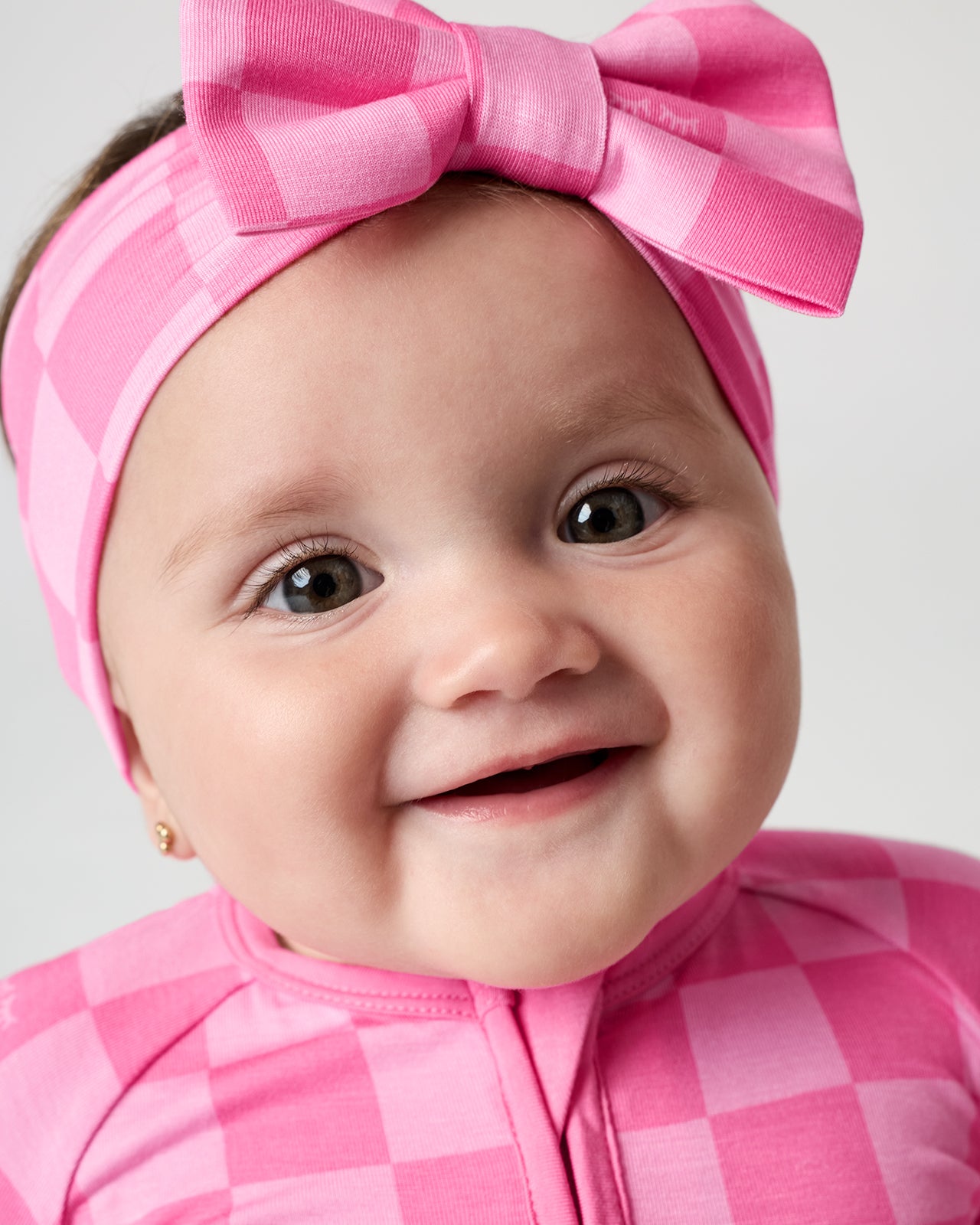 Close up of baby wearing the Sweet Raspberry Checks Luxe Bow Headband
