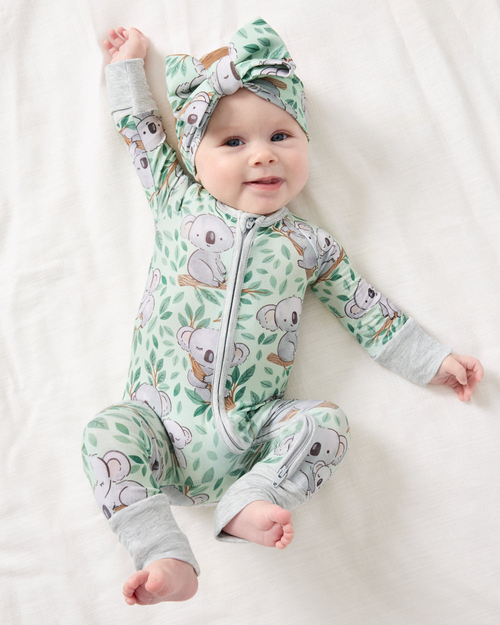 Baby girl wearing the Koala Cuddles Zippy with a matching bow