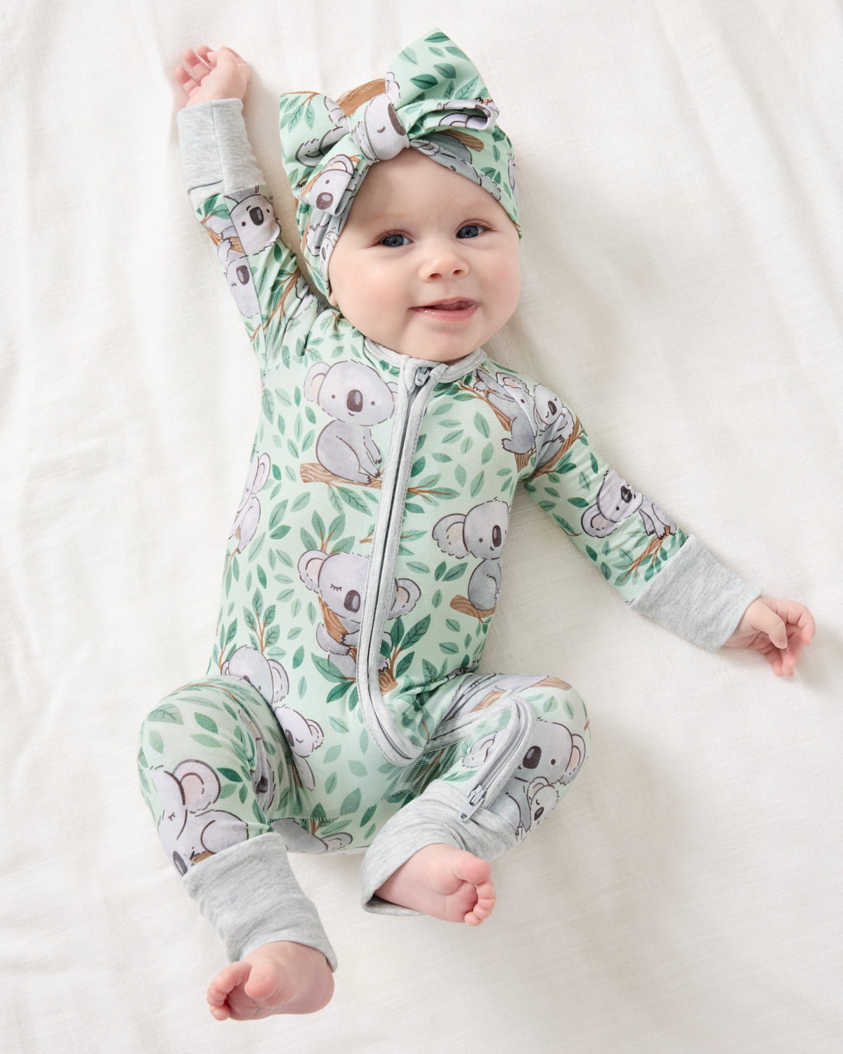 Baby girl wearing the Koala Cuddles Zippy with a matching bow