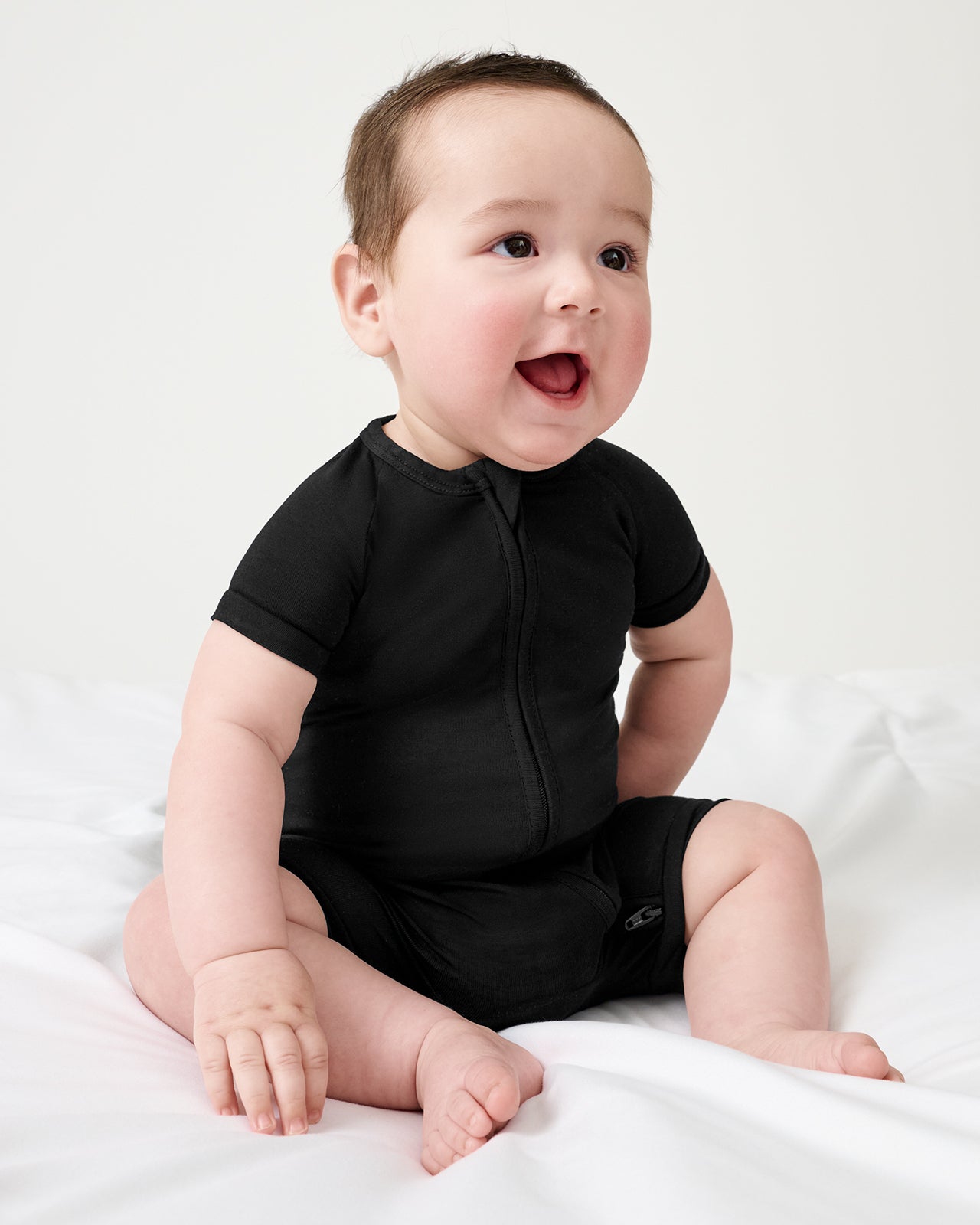 Sitting baby wearing the Black Shorty Zippy