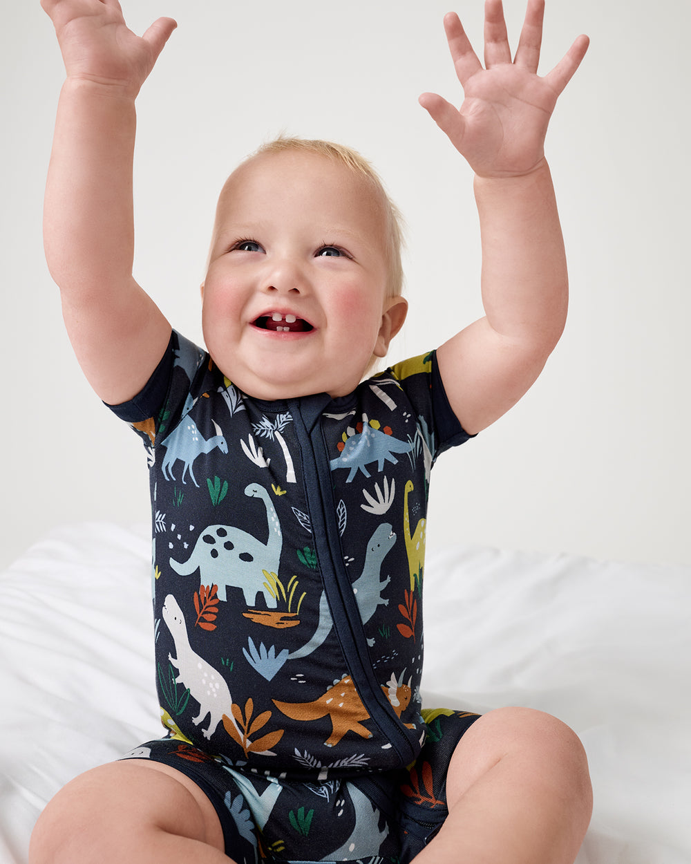 Sitting boy wearing the Navy Jurassic Jungle Shorty Zippy