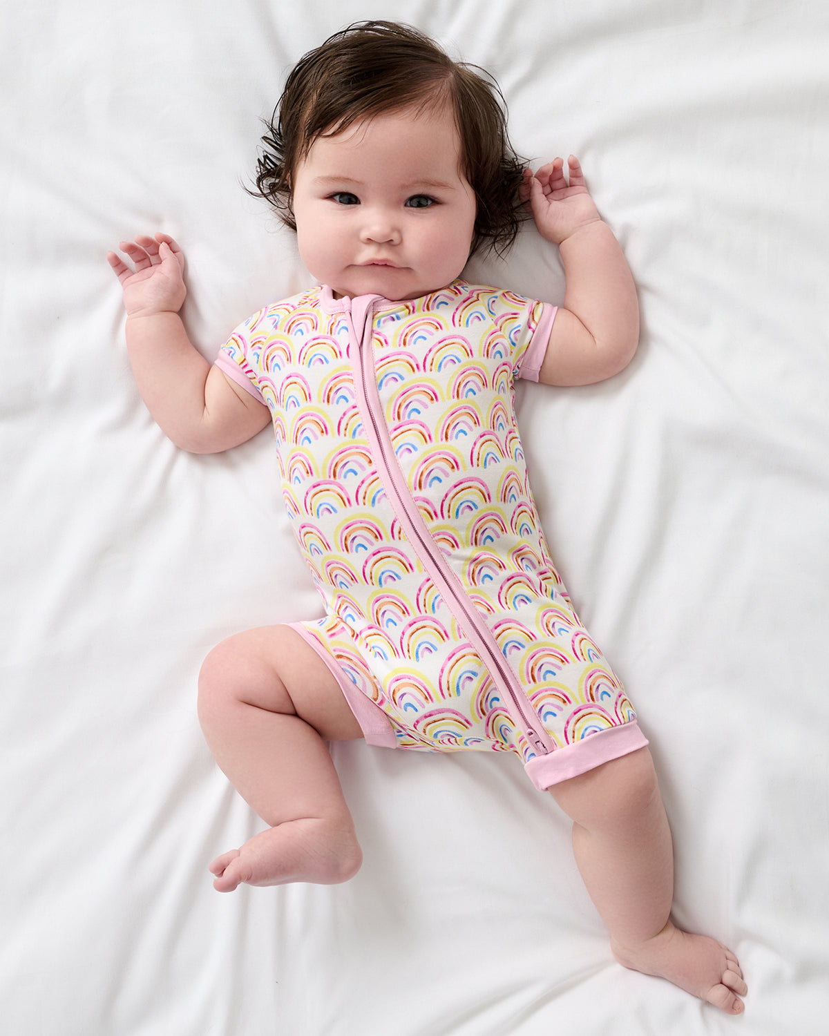 Overhead view of baby wearing the Pastel Rainbows Shorty Zipper Pajama