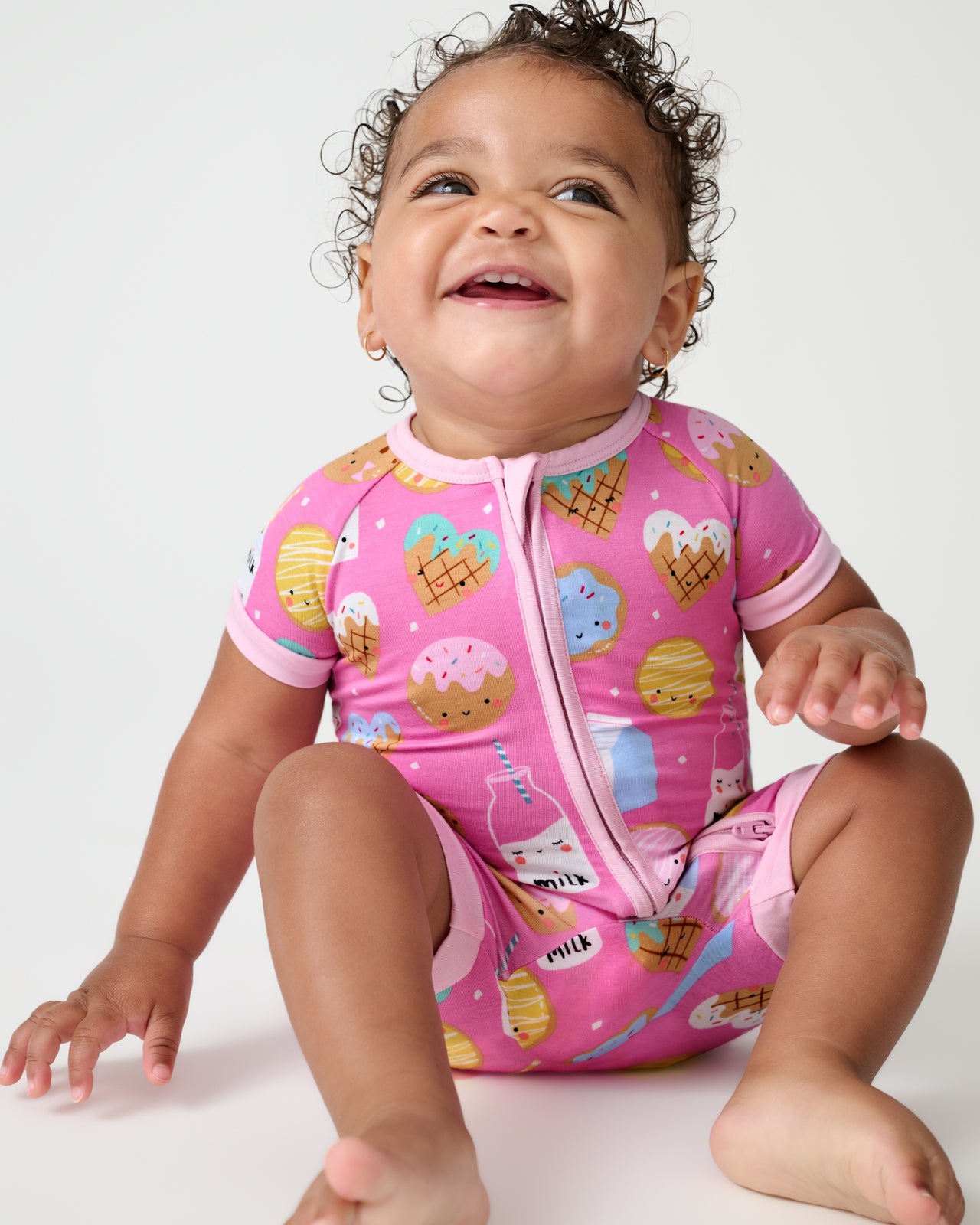 Sitting baby wearing the Pink Cookies & Milk Shorty Zippy