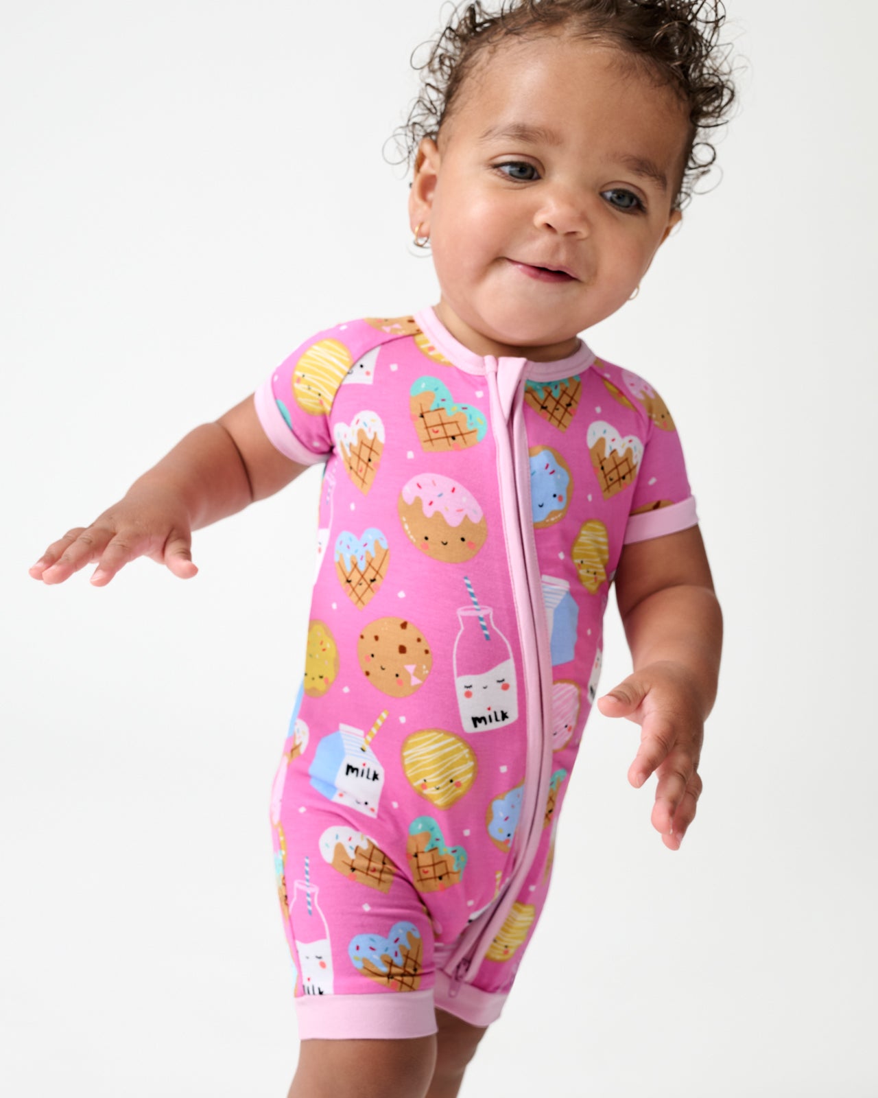Walking toddler wearing the Pink Cookies & Milk Shorty Zippy
