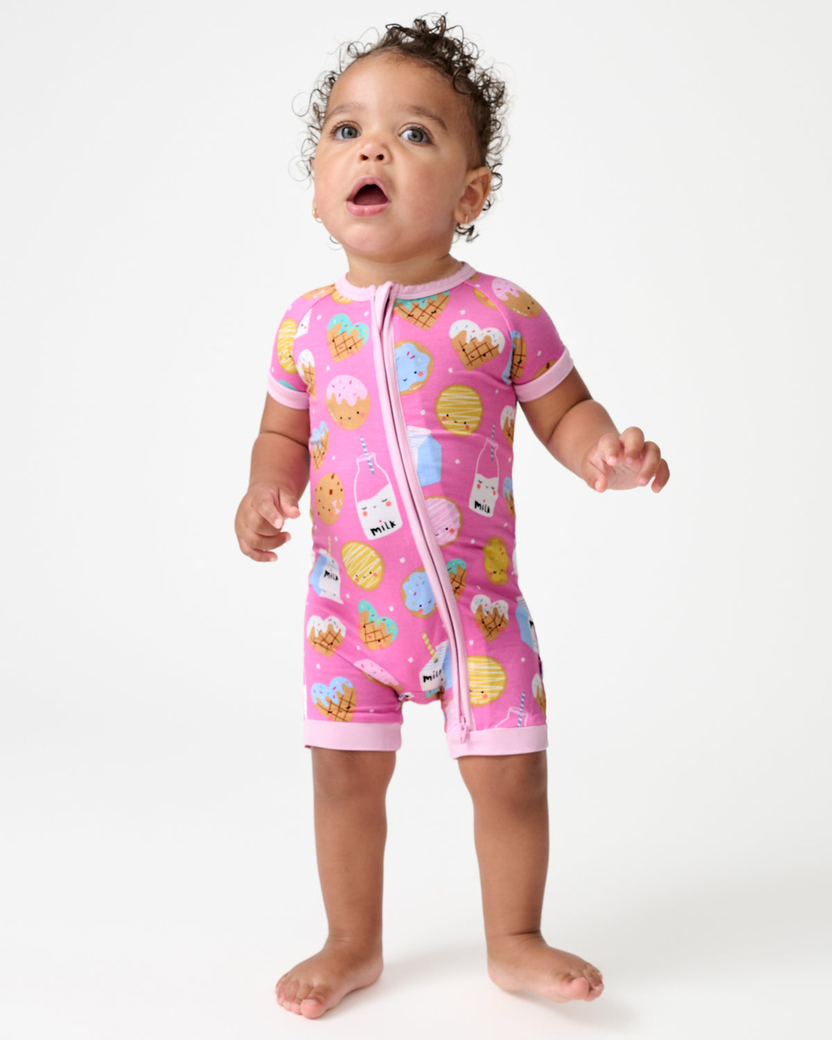 Standing baby wearing the Pink Cookies & Milk Shorty Zippy