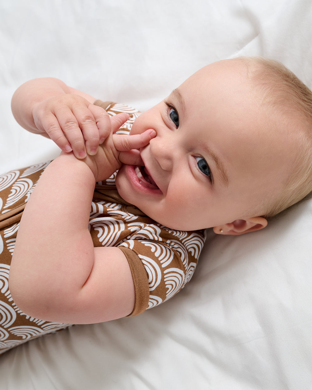 Close up of baby wearing the Rust Rainbows Shorty Zippy