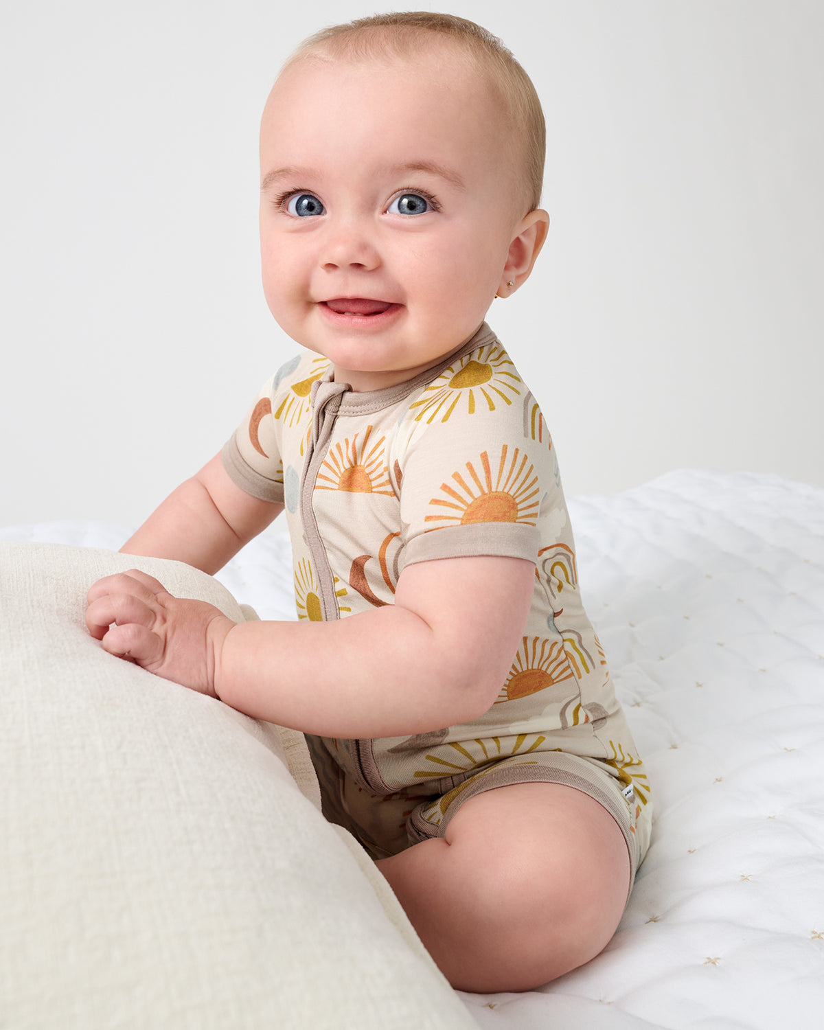 Sitting baby wearing the Desert Sunrise Bamboo Shorty Zippy