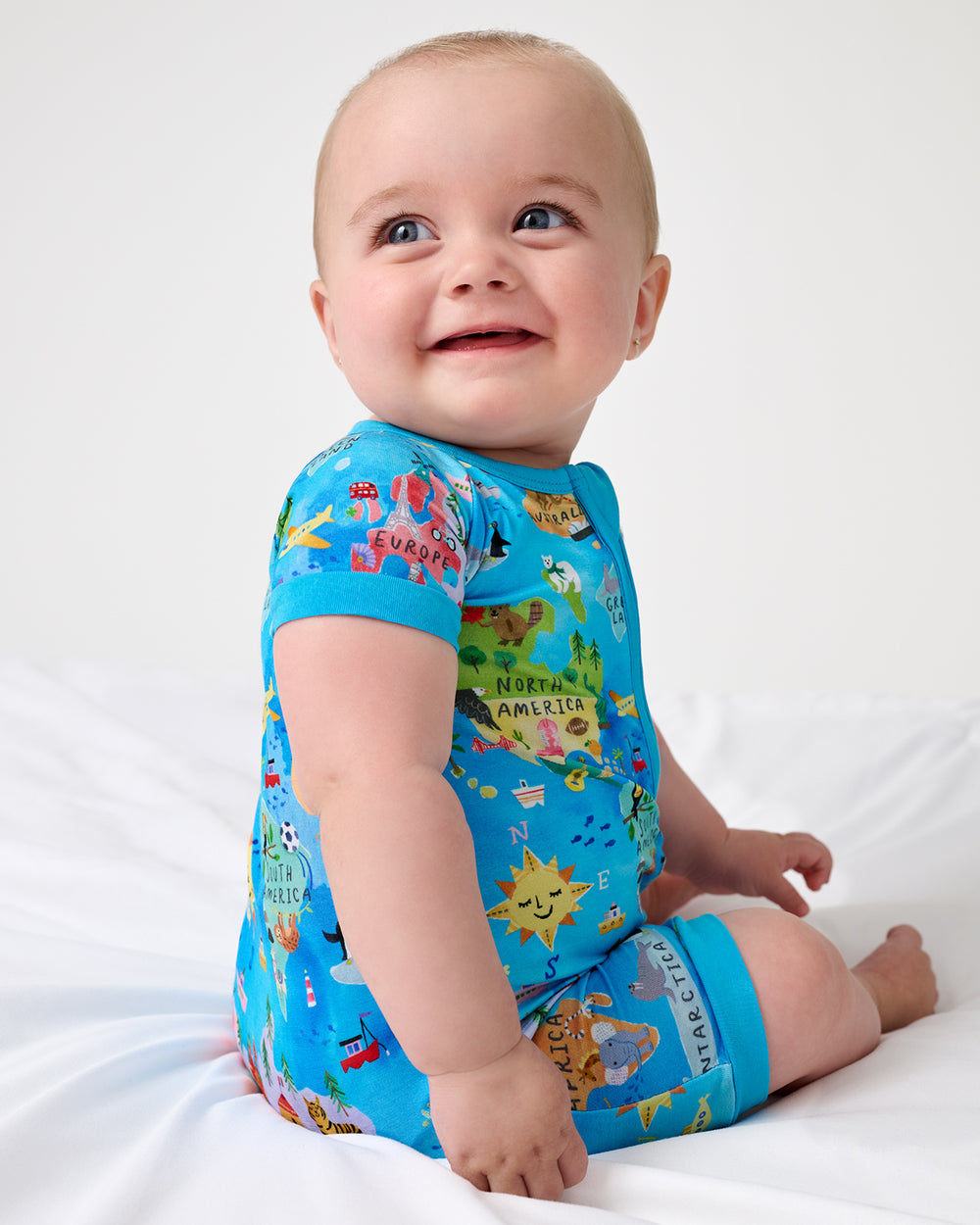 Sitting newborn wearing the Around The World Shorty Zippy