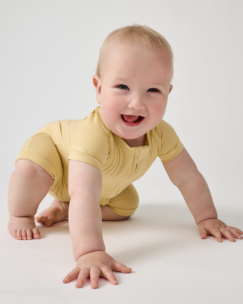 Crawling baby wearing the Sunglow Shorty Zippy 