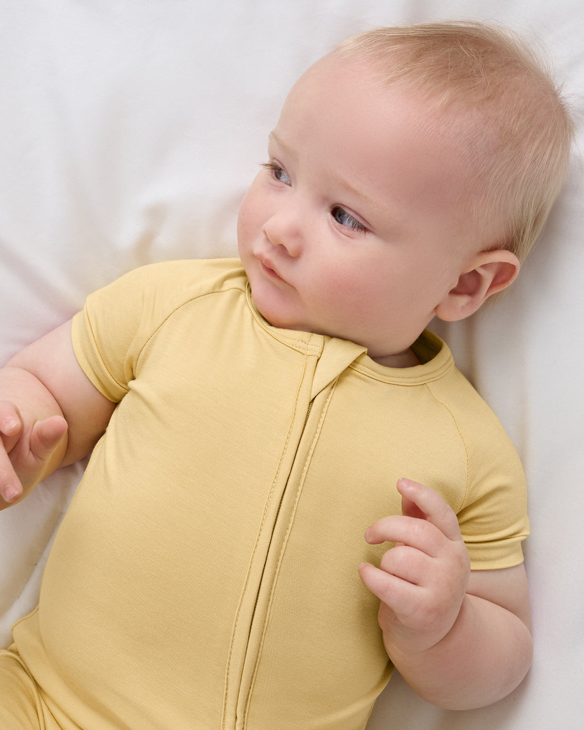 Close up aerial view of baby wearing the Sunglow Shorty Zippy