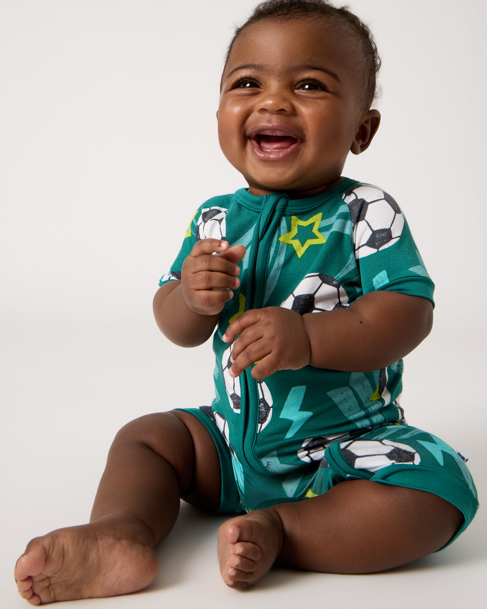 Front view of sitting baby wearing the Soccer Stars Shorty Zippy