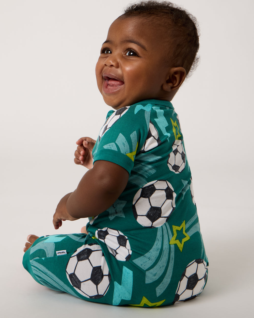 Back view of sitting baby wearing the Soccer Stars Shorty Zippy