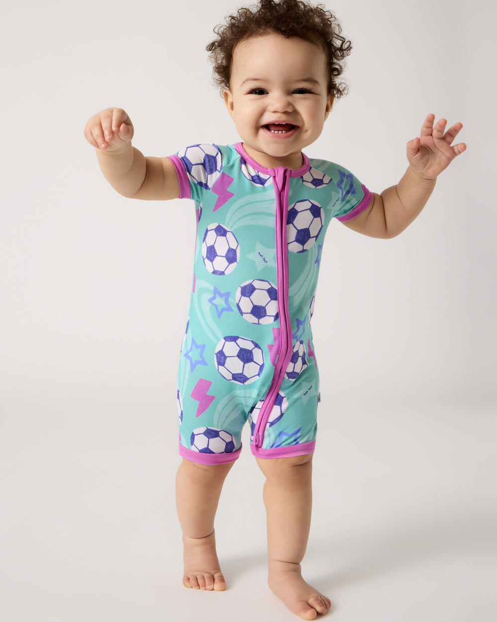 Walking baby wearing the Aqua Soccer Stars Shorty Zippy