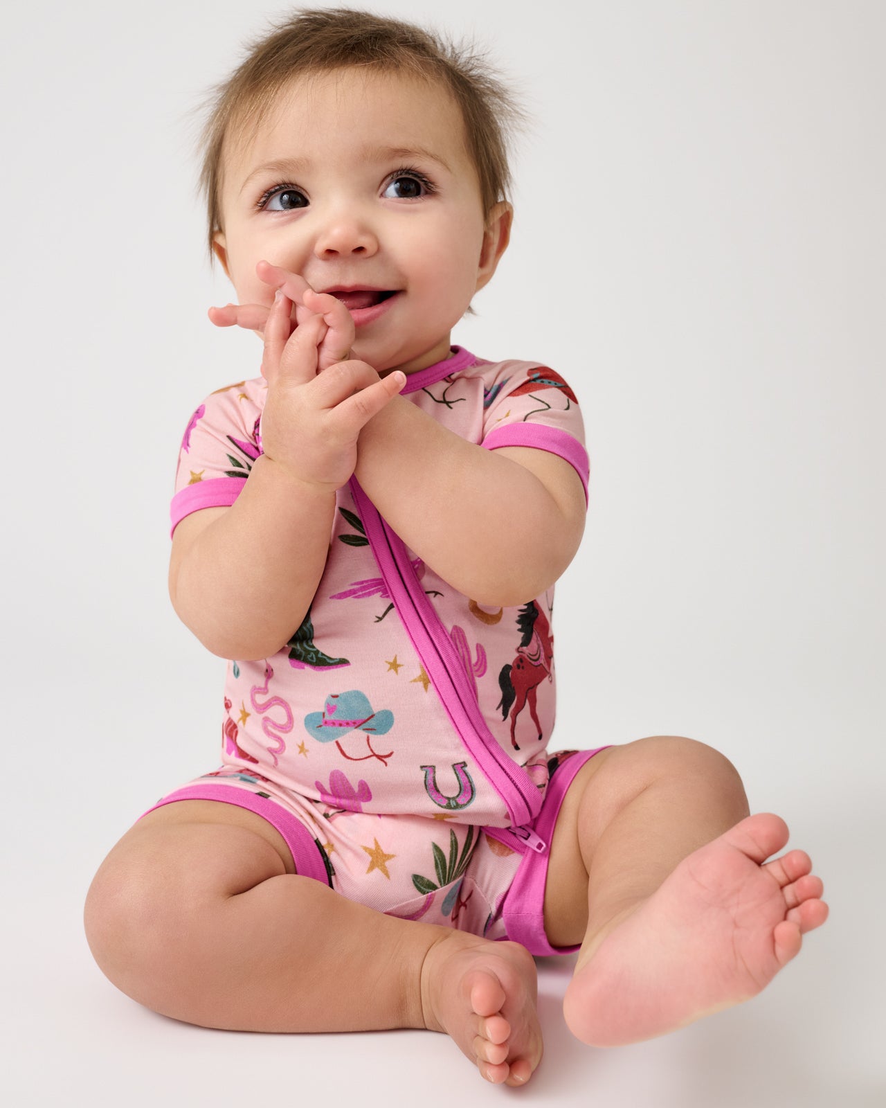 Sitting baby wearing the Pink Rancher Roundup Shorty Zippy