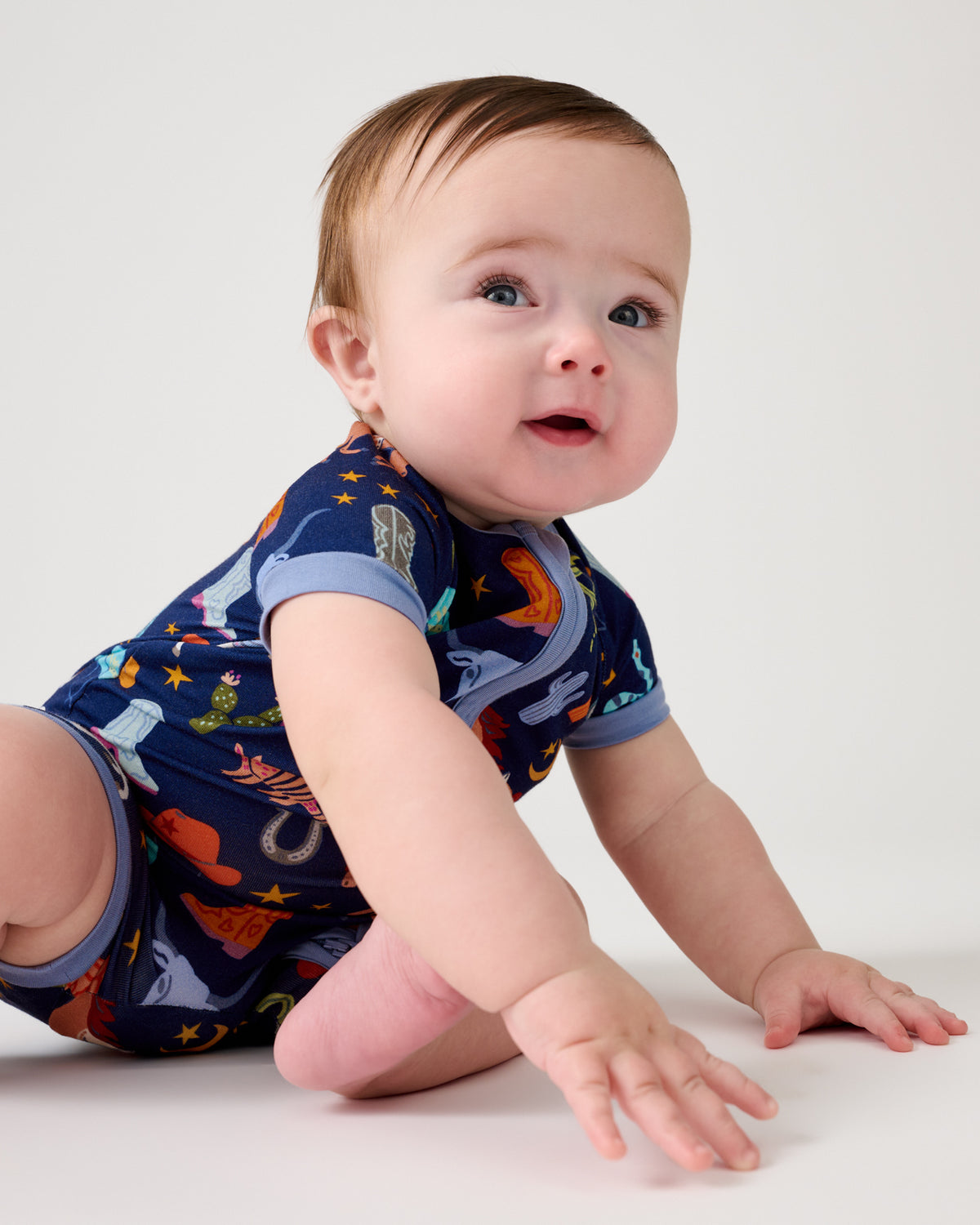 Crawling baby wearing the Blue Rancher Roundup Shorty Zipper Pajama