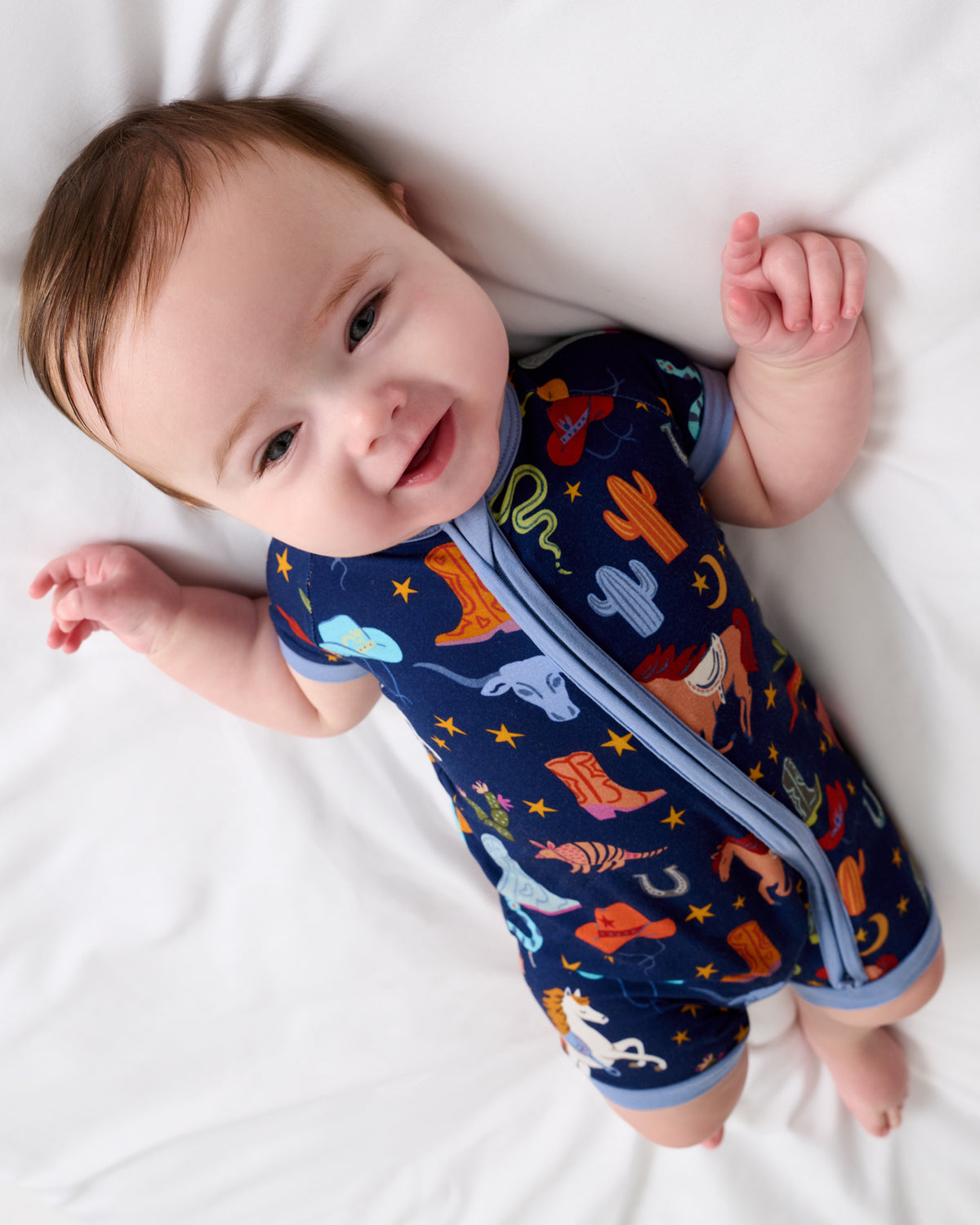 Baby on a white blanket wearing the Blue Rancher Roundup Shorty Zippy