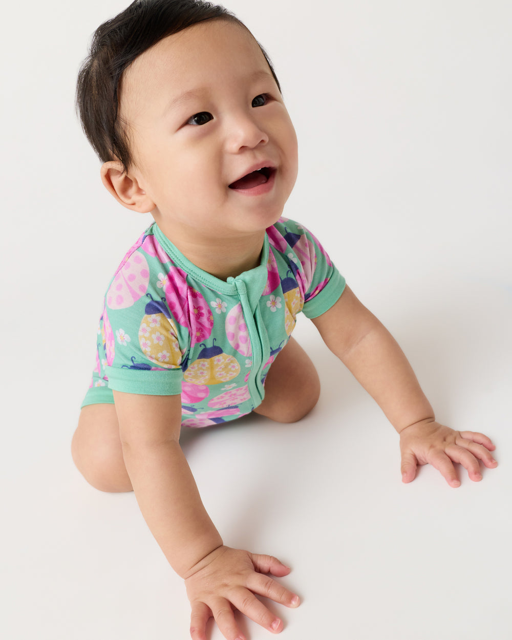 Crawling baby wearing the Ladybug Meadow Shorty Zippy