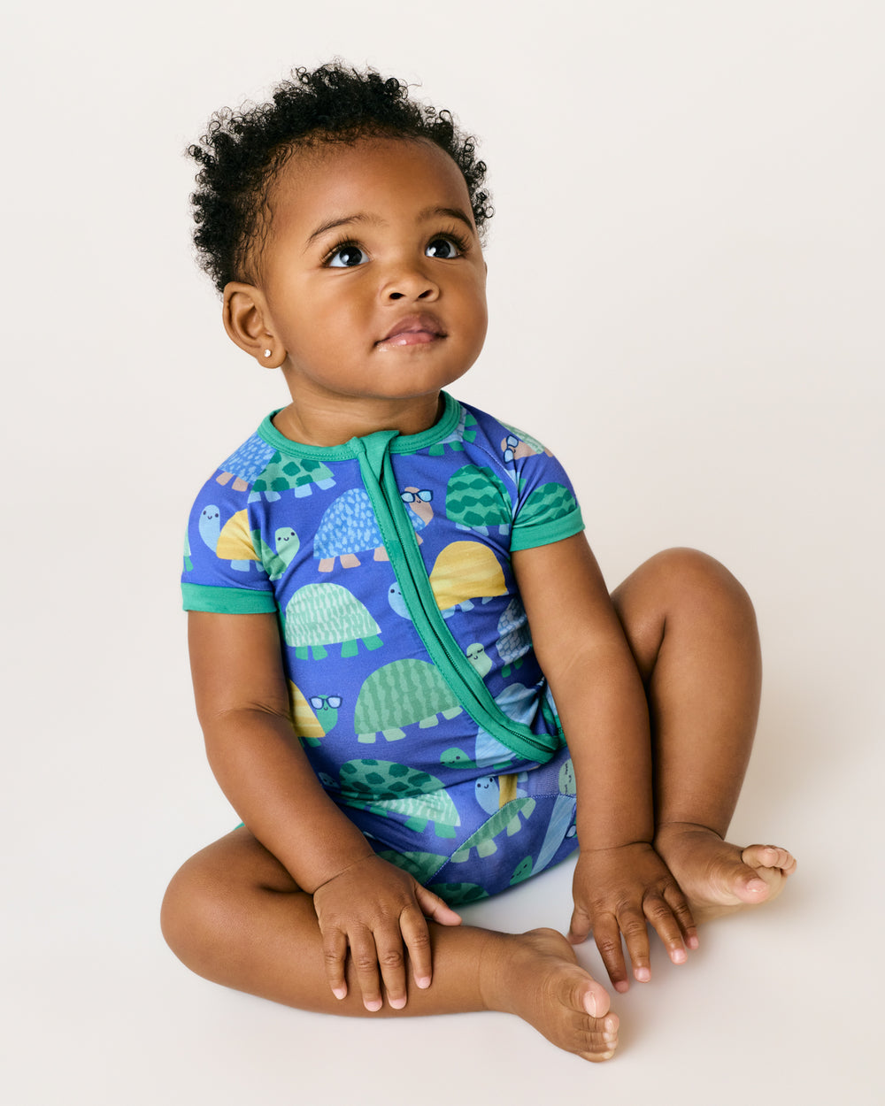 Sitting child wearing the Shell Parade Shorty Zippy