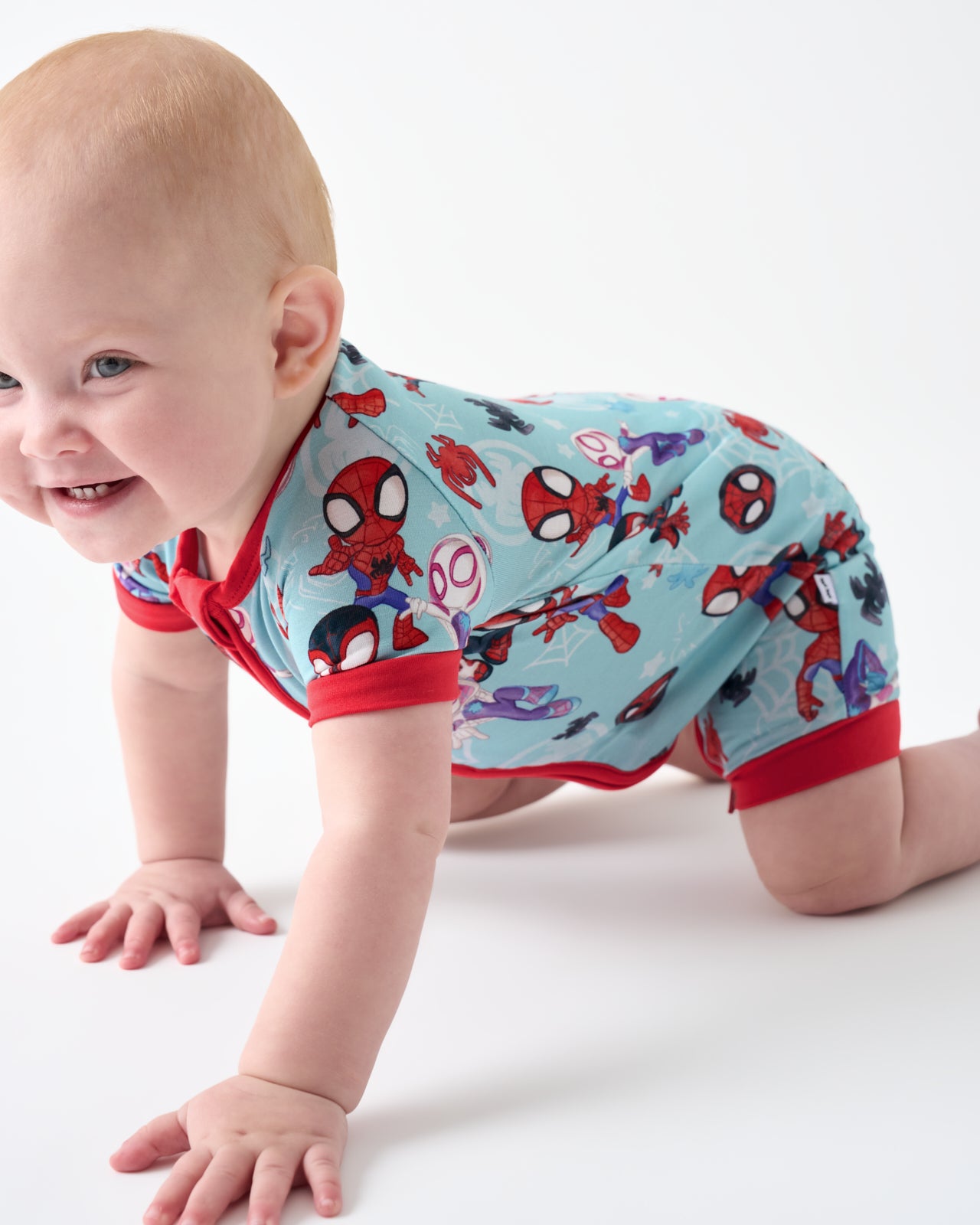 Crawling baby wearing the Spidey & Friends Tiny Webs Shorty Zippy