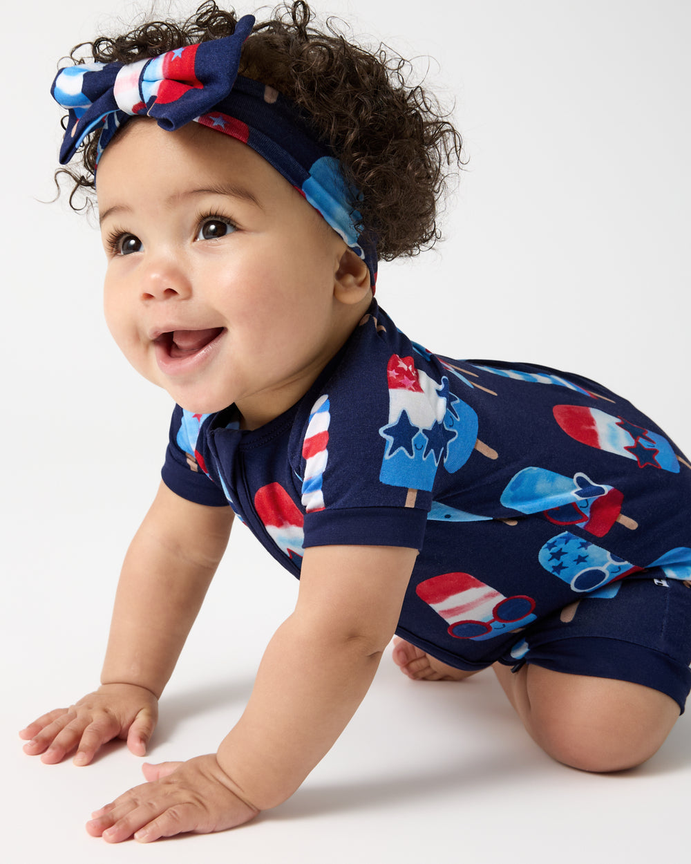 Crawling baby wearing the Sparkle Treats Shorty Zippy and Luxe Bow Headband