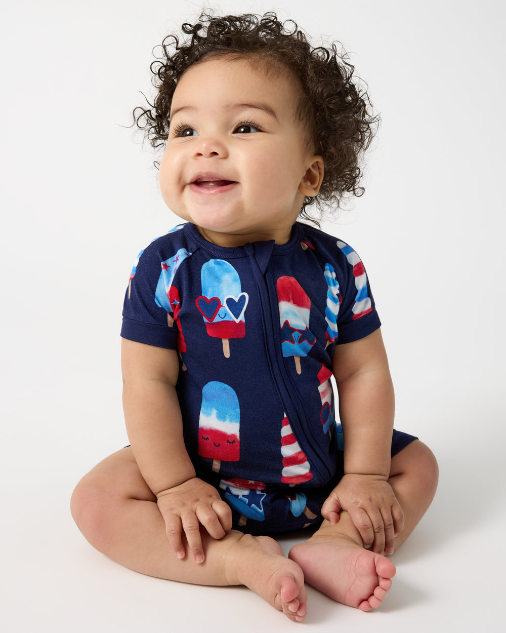 Sitting newborn wearing the Sparkle Treats Shorty Zippy Pajama