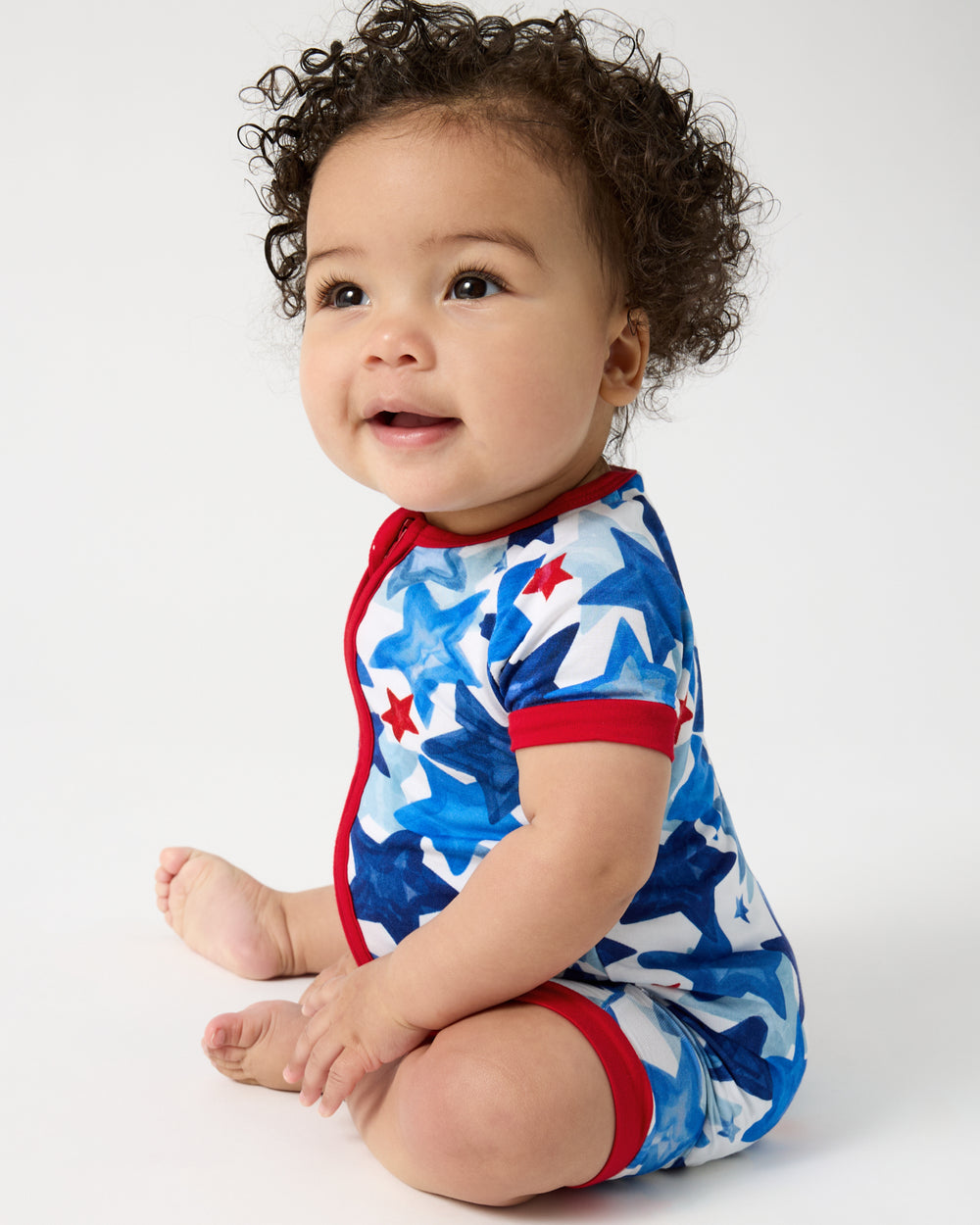 Sitting baby wearing the Starry Splash Shorty Zippy
