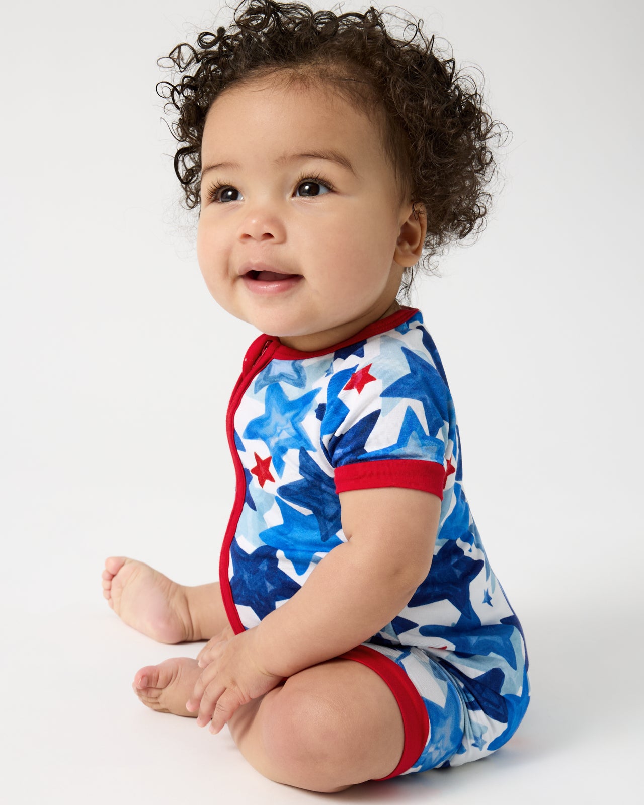 Sitting baby wearing the Starry Splash Shorty Zippy