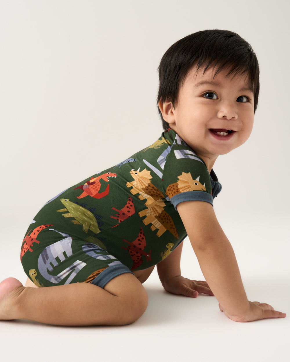Crawling baby wearing the Green Roar & Explore Shorty Zippy